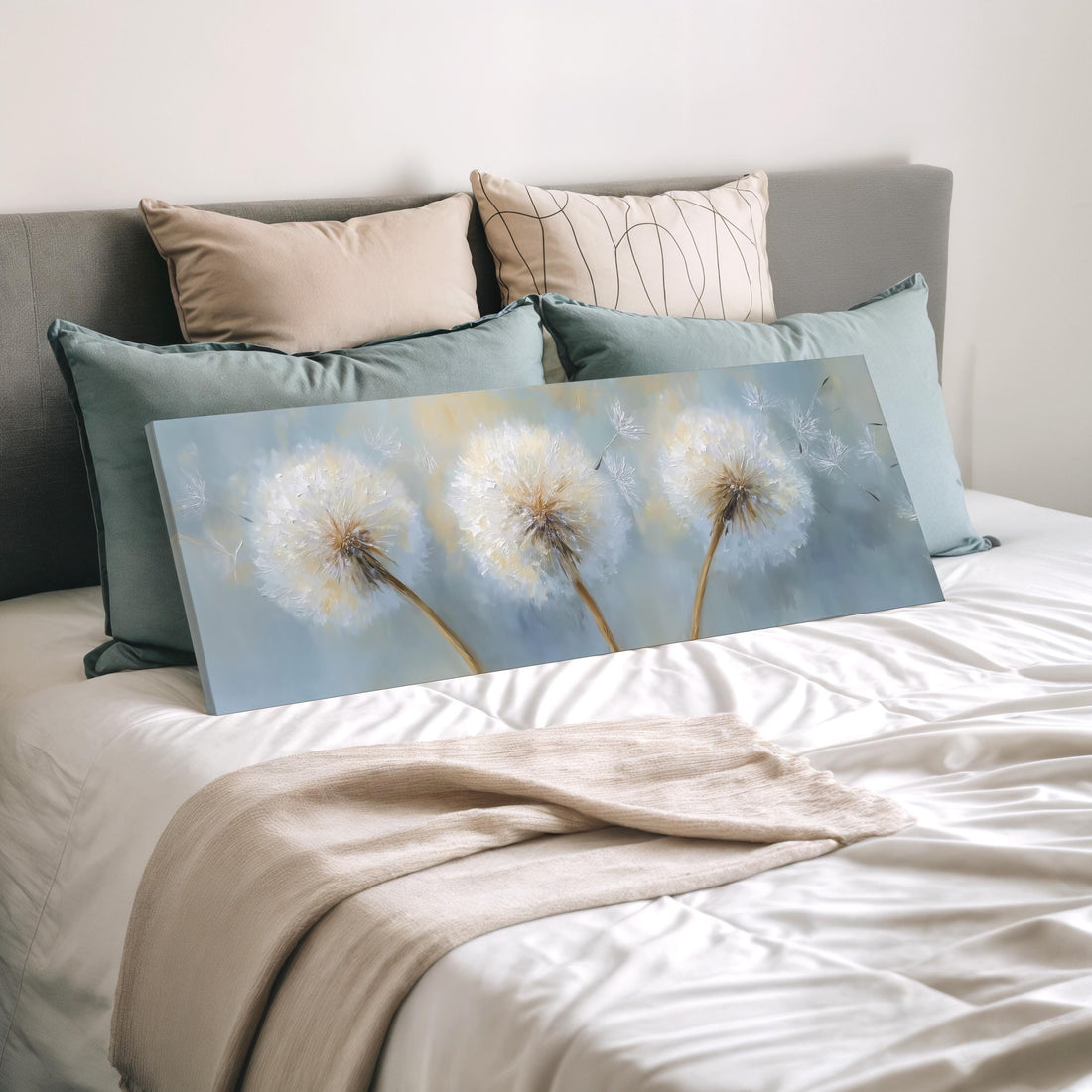 a bedroom with a large bed adorned with white pillows and a blue blanket. Above the bed, there is a painting of three dandelions against a blue background.