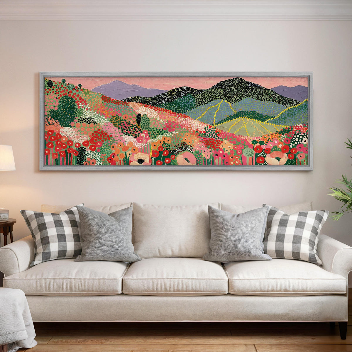 Dotted poppy mountains under a pink sky panoramic canvas print above a white sofa in a bright living room
