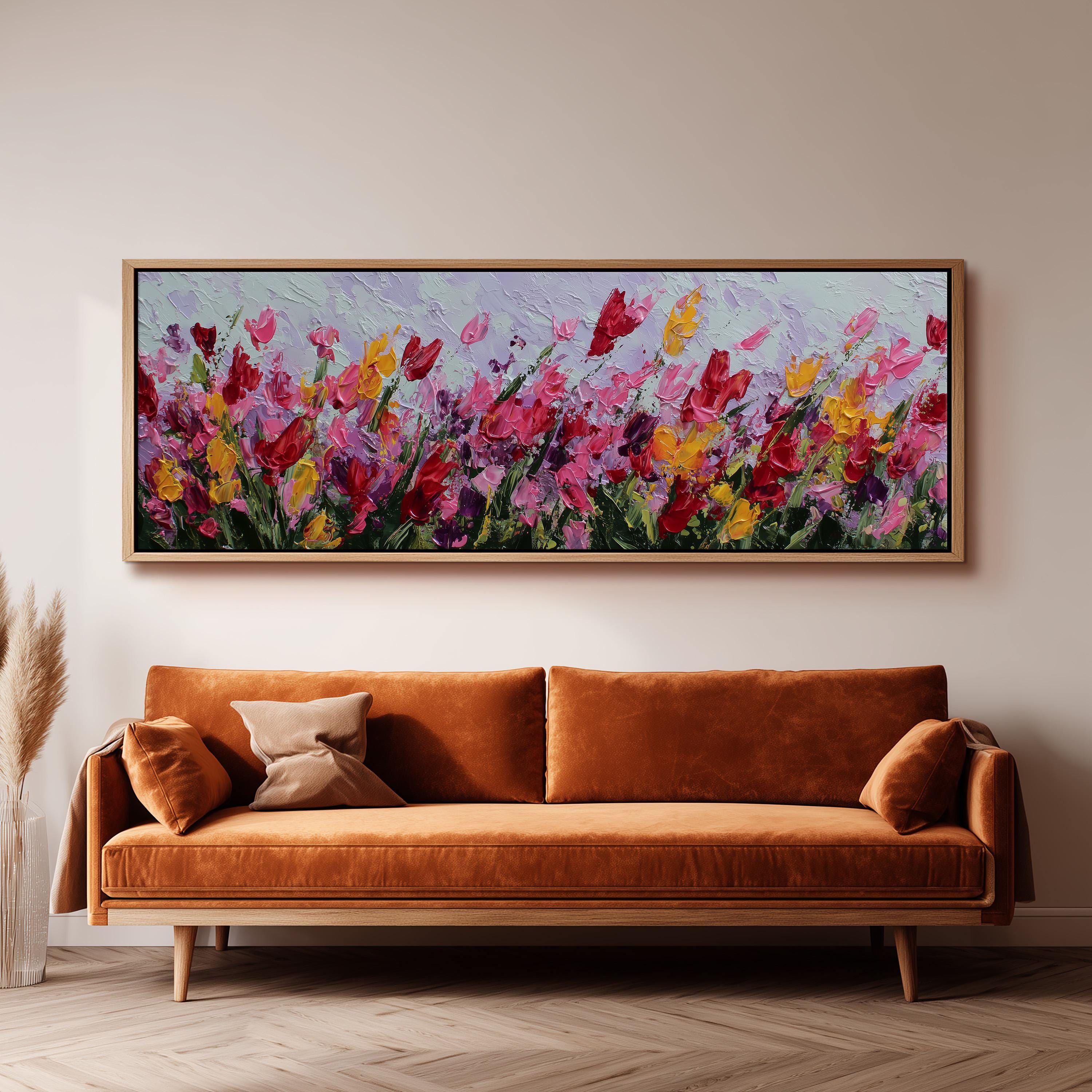 a large, vibrant painting of flowers hanging on a wall above a brown sofa.
