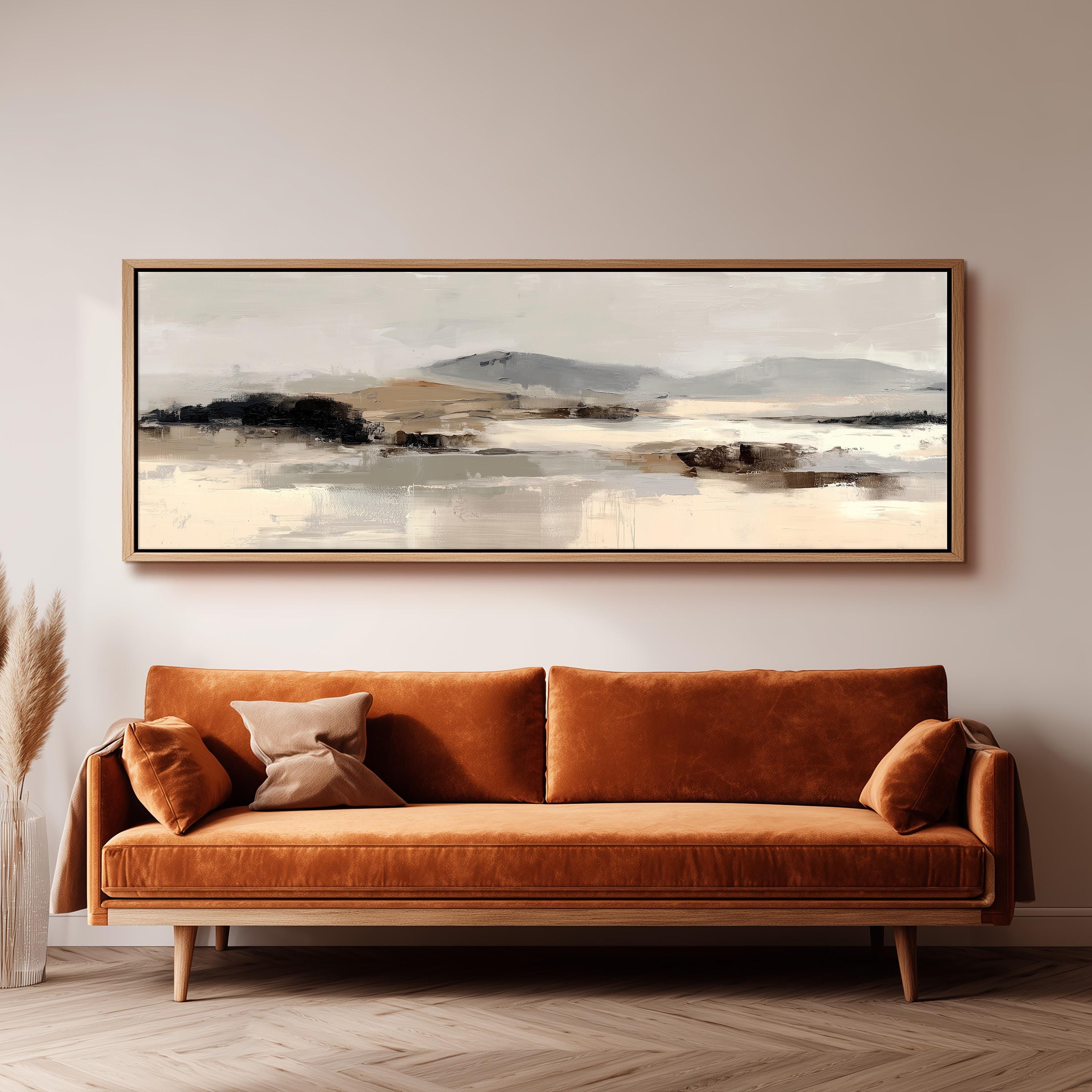 a large, rectangular painting hanging on a wall above a brown sofa with orange cushions.