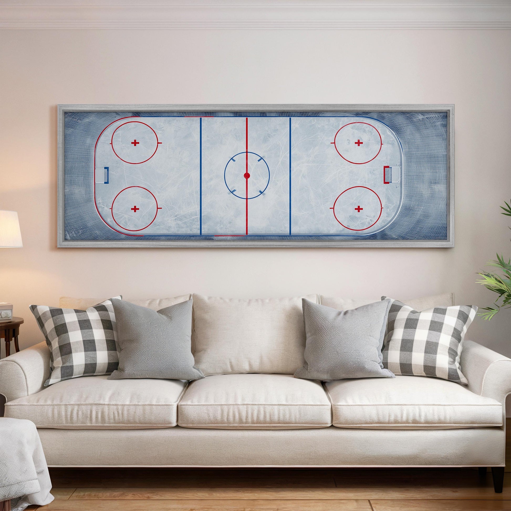 a large framed hockey rink with a blue and white color scheme, mounted on a wall above a white couch with gray and white patterned pillows.