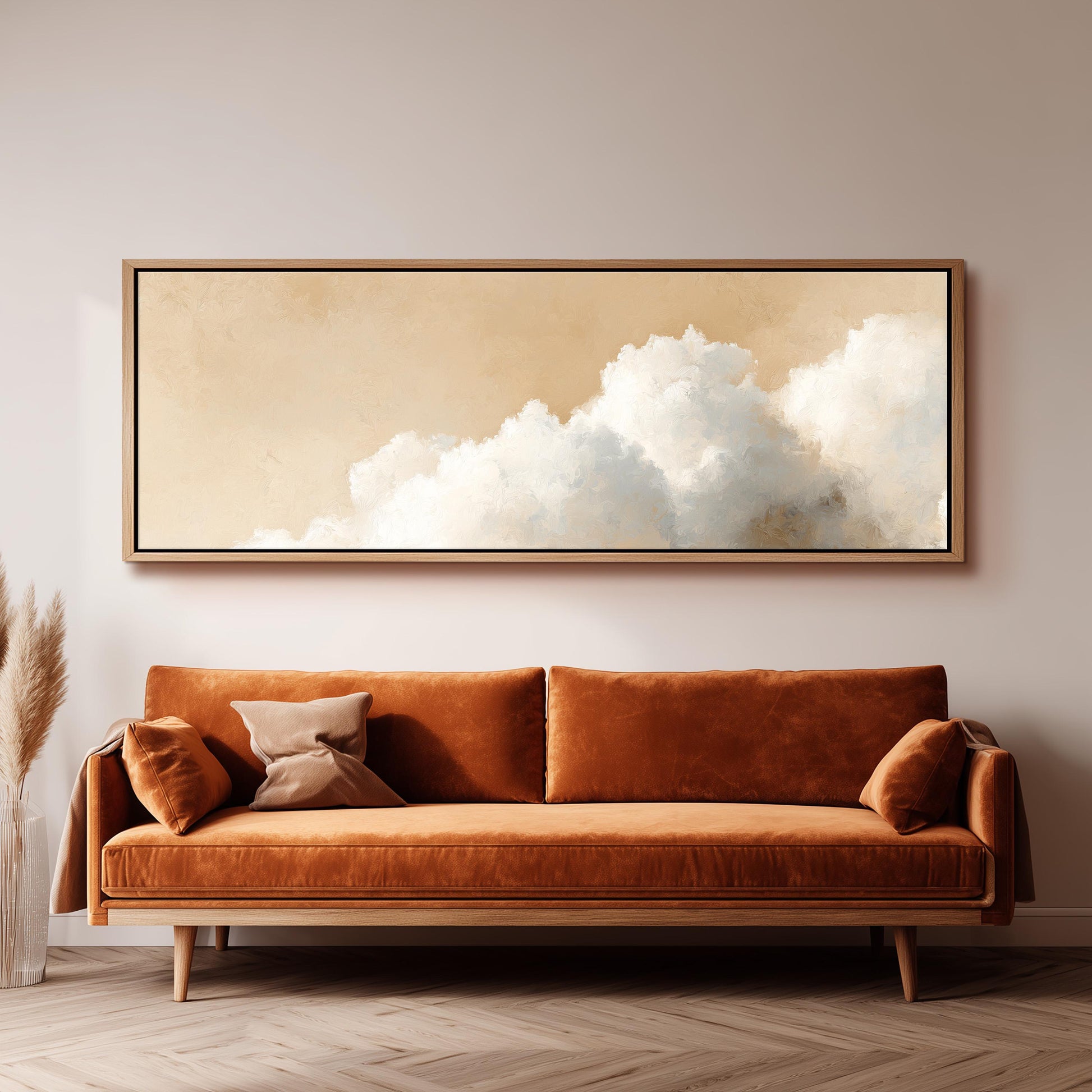 a large, framed painting of a cloudy sky hanging above a brown sofa with two pillows.