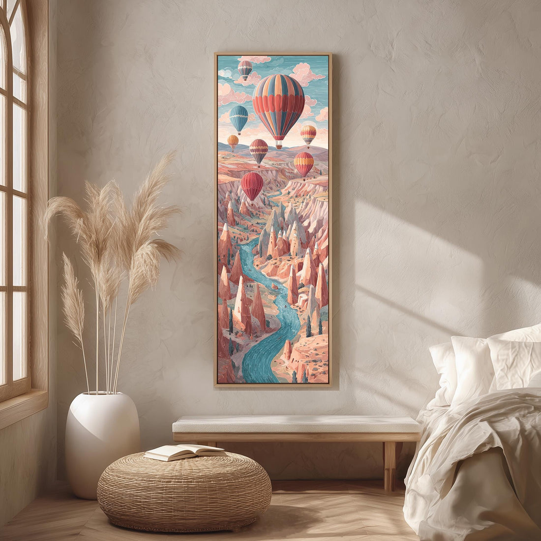 a large, colorful painting of hot air balloons floating over a mountainous landscape, hanging on a wall in a room with a bed, a potted plant, and a woven ottoman.