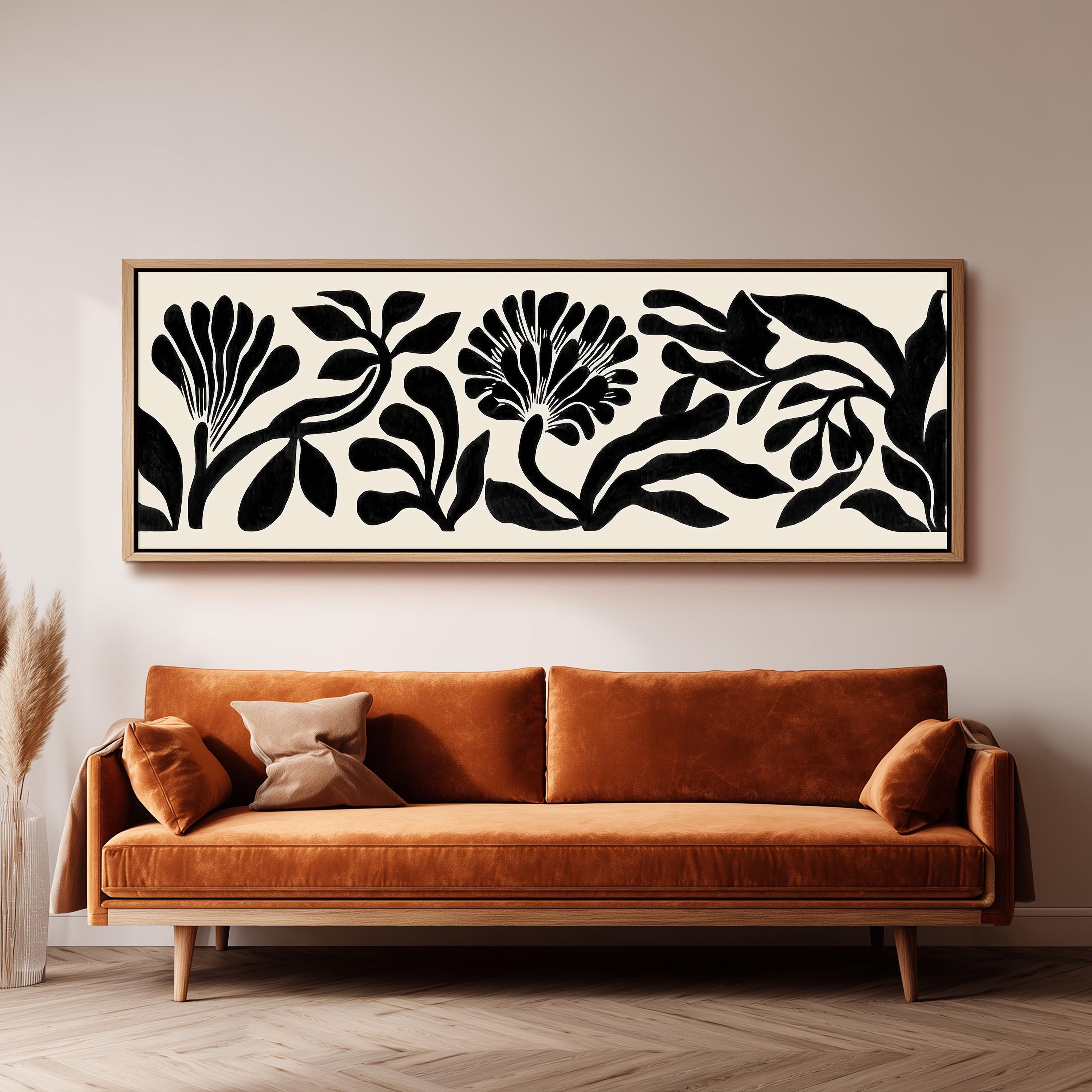 a large black and white abstract floral artwork hanging on a wall above a brown sofa.