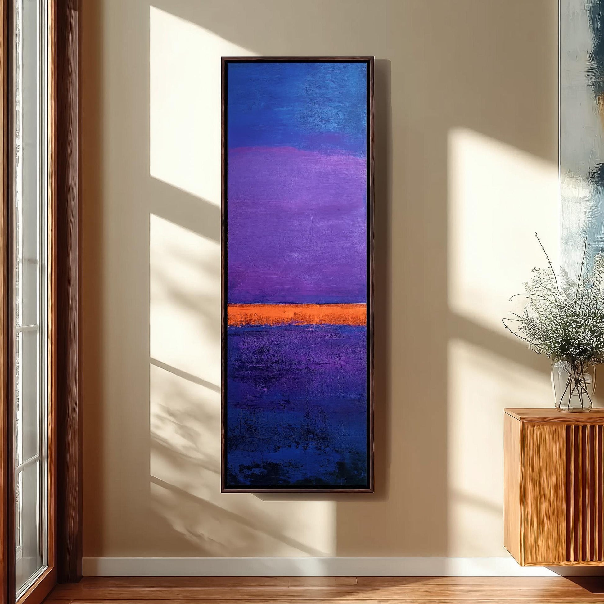a large, rectangular painting hanging on a wall, depicting a vibrant sunset scene with a purple sky and an orange horizon.