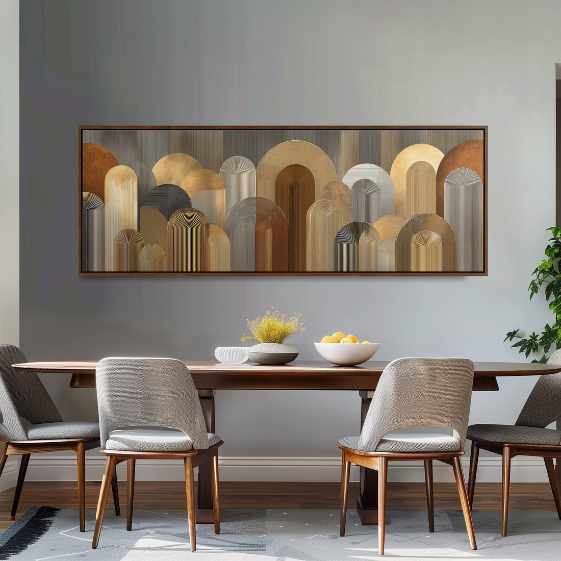 a modern dining room with a wooden table and four upholstered chairs. Above the table, there is a large abstract painting with a repeating pattern of circles and arches in various shades of brown and beige. The table is set with a bowl of fruit and a vase of flowers, creating a warm and inviting atmosphere.