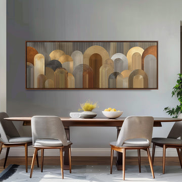 a modern dining room with a wooden table and four upholstered chairs. Above the table, there is a large abstract painting with a repeating pattern of circles and arches in various shades of brown and beige. The table is set with a bowl of fruit and a vase of flowers, creating a warm and inviting atmosphere.