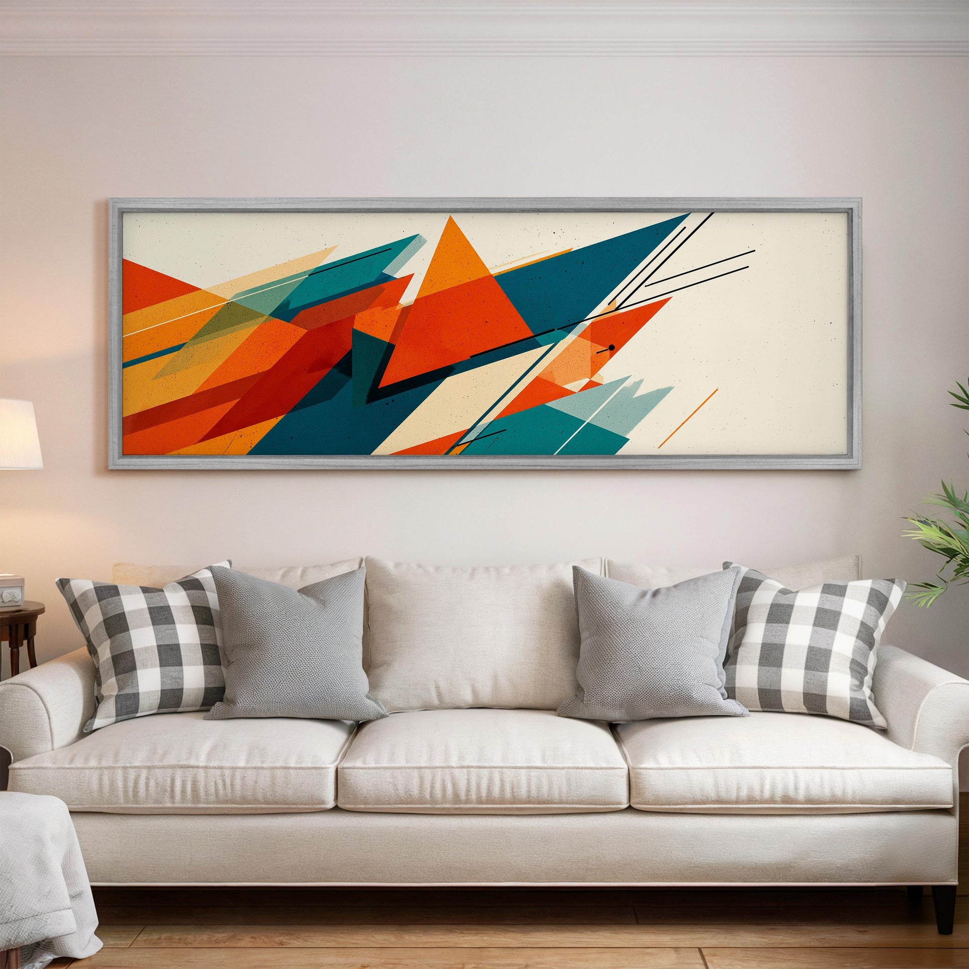 a large abstract painting hanging on a wall above a white couch with gray and white plaid throw pillows.