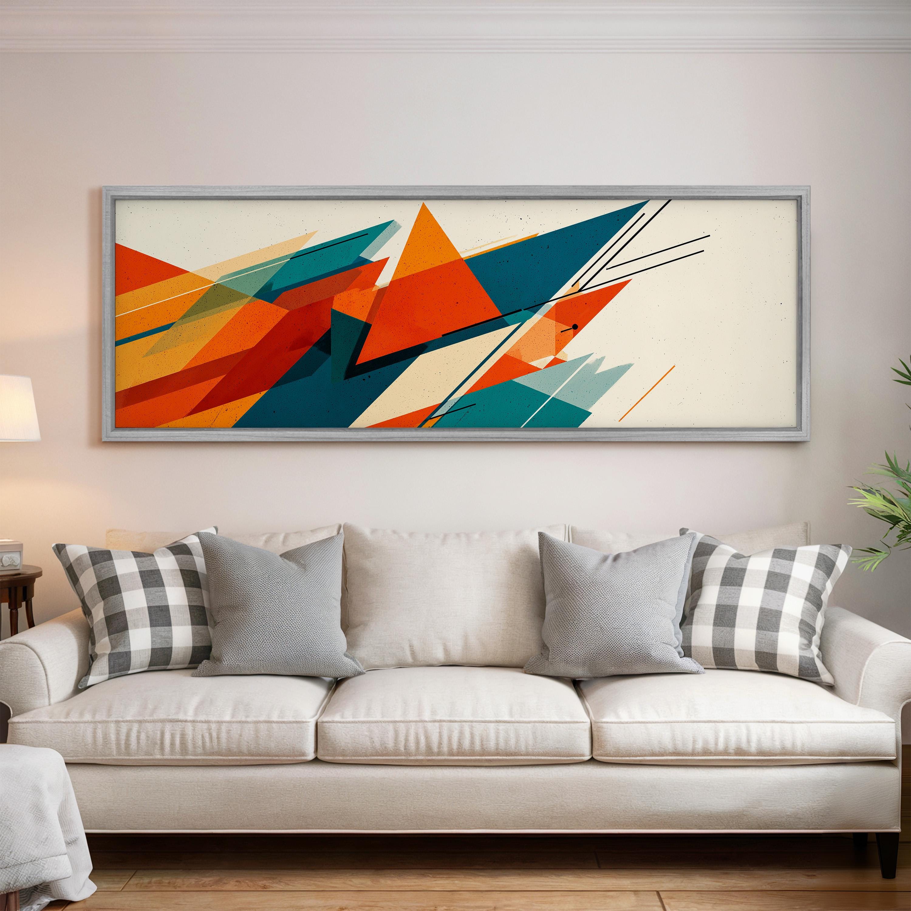 a large abstract painting hanging on a wall above a white couch with gray and white plaid throw pillows.