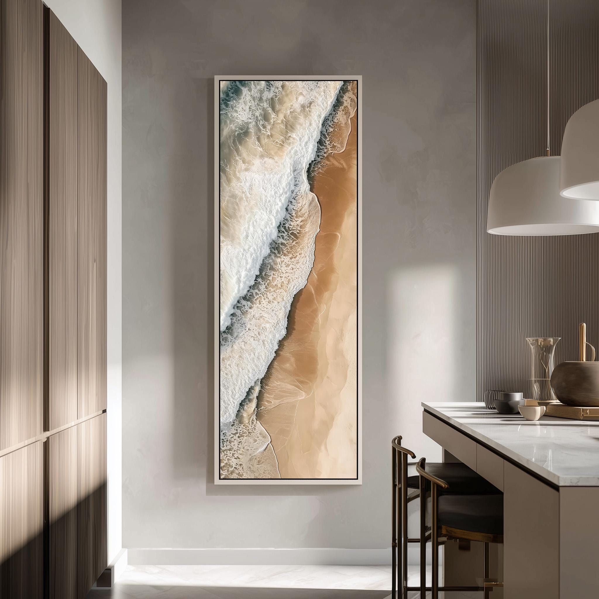 a large, framed painting of a beach scene hanging on a wall in a modern, minimalist kitchen.