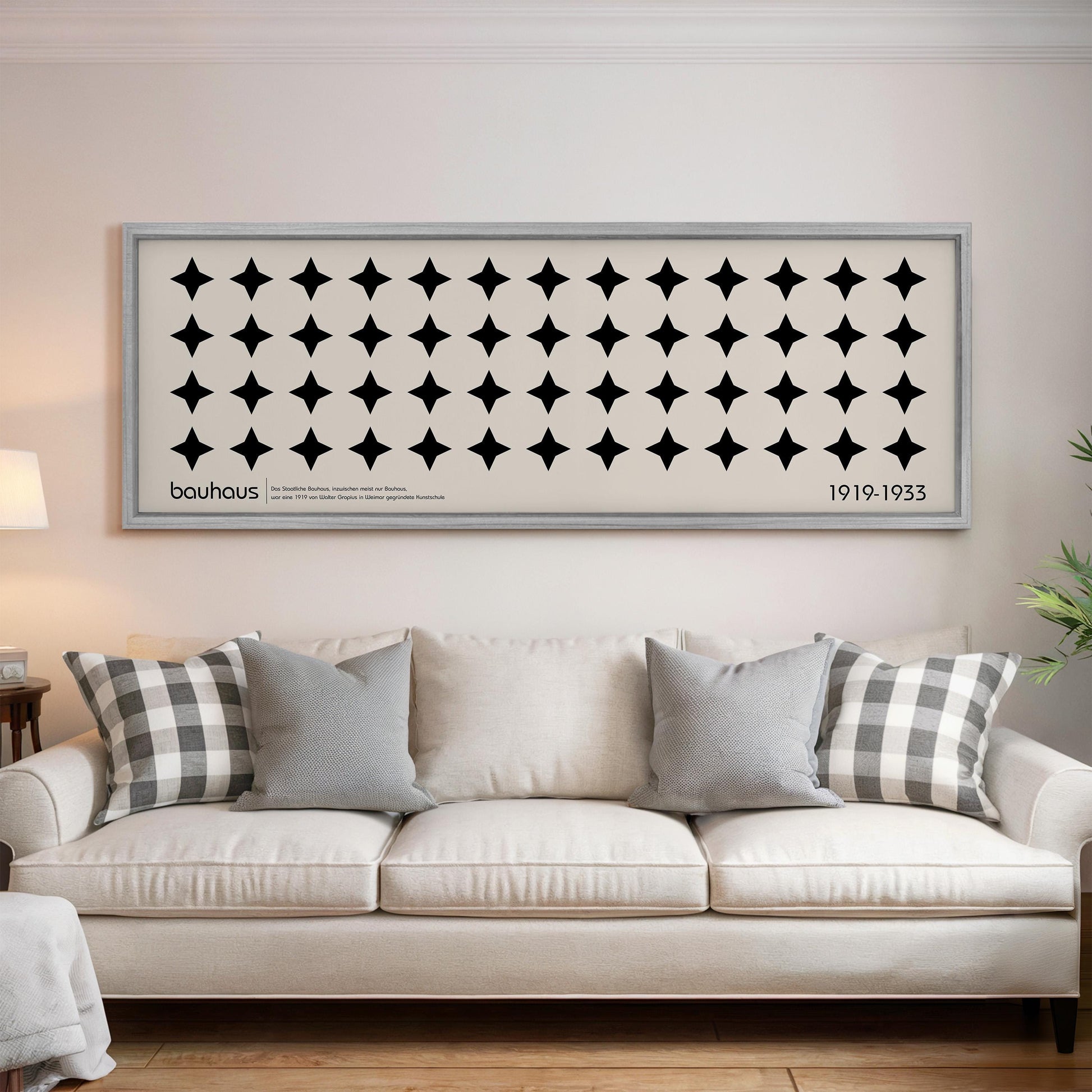 a living room with a white sofa and a framed artwork hanging on the wall above it.