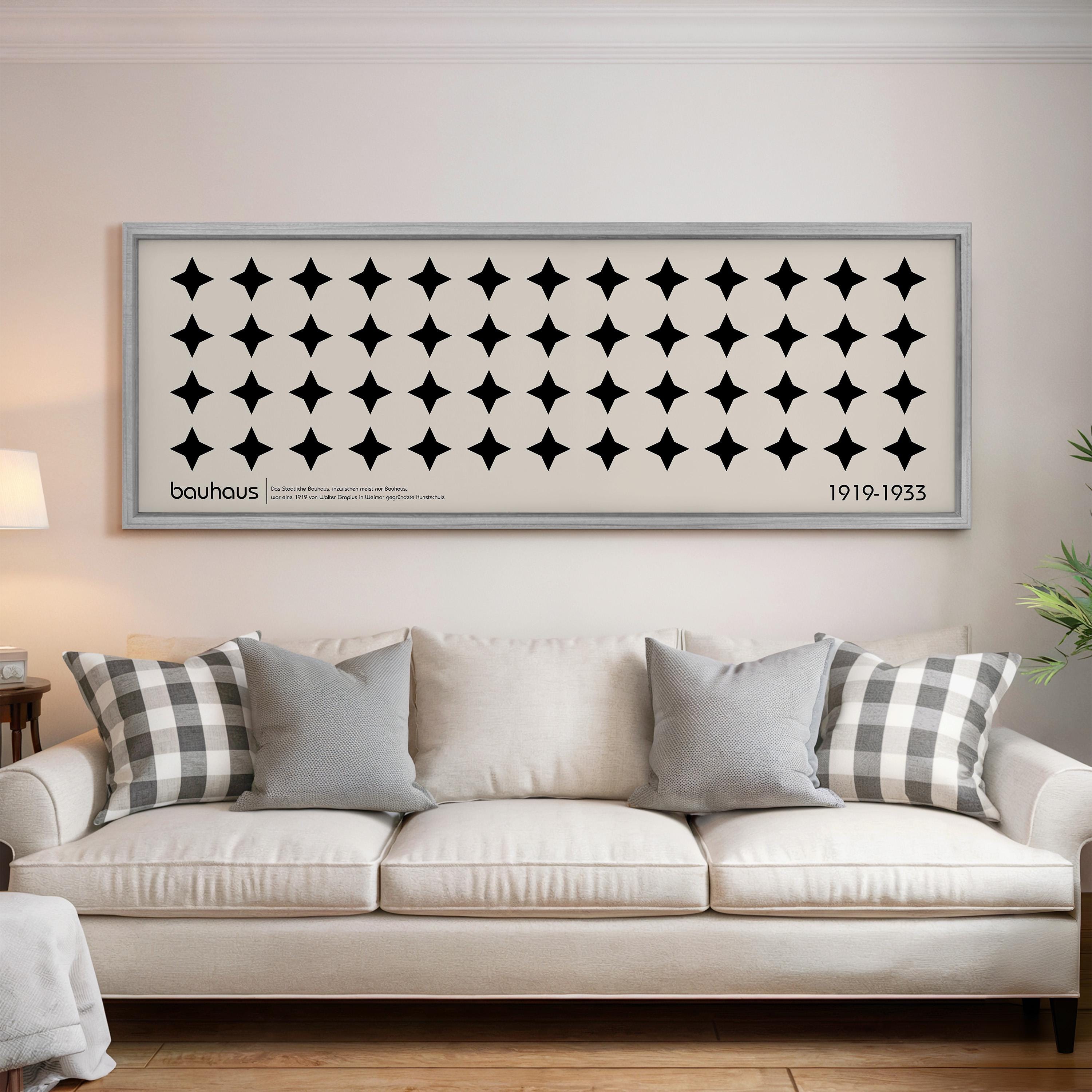 a living room with a white sofa and a framed artwork hanging on the wall above it.