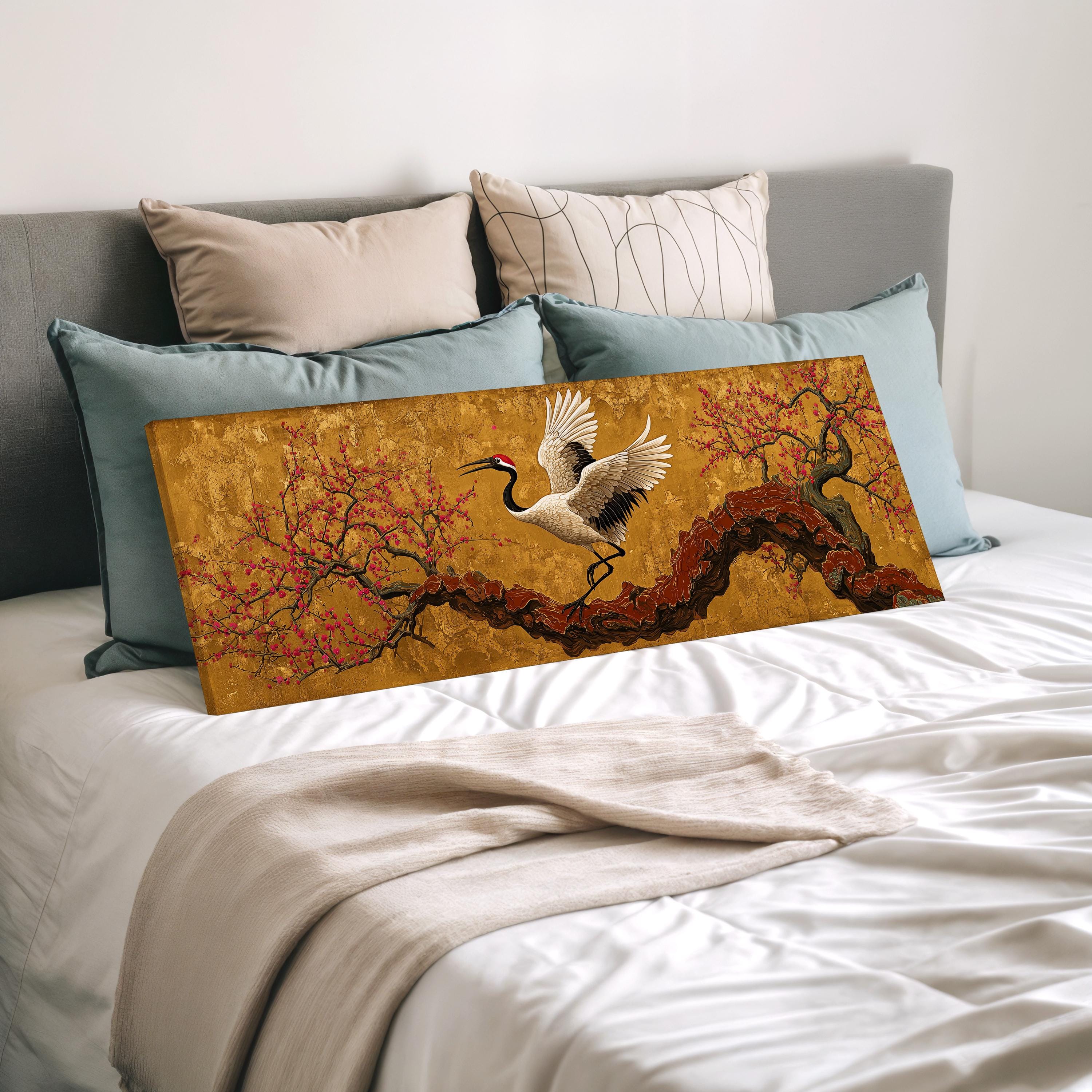a large painting of a crane on a branch, displayed on a bed with a white comforter and pillows.