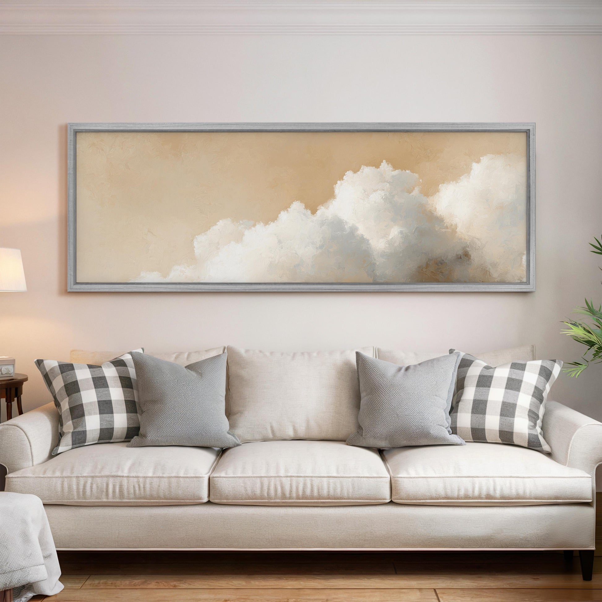a large, framed painting of a cloud hanging above a white couch with gray and black plaid throw pillows.