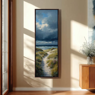 a large framed painting hanging on a wall, depicting a scenic landscape with a path leading to the ocean.