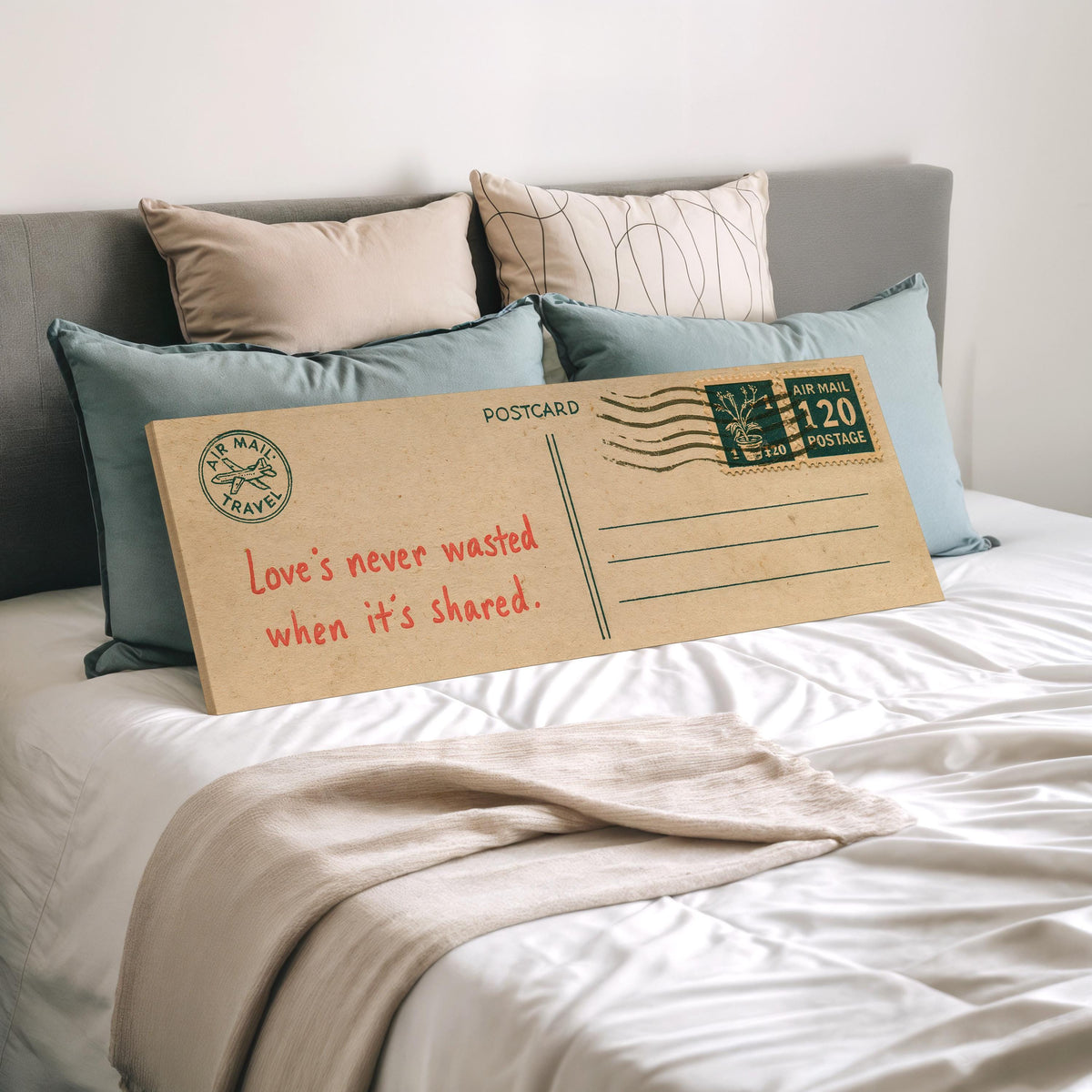 Vintage postcard with a love quote wide panoramic canvas print laid on a bed to show its size