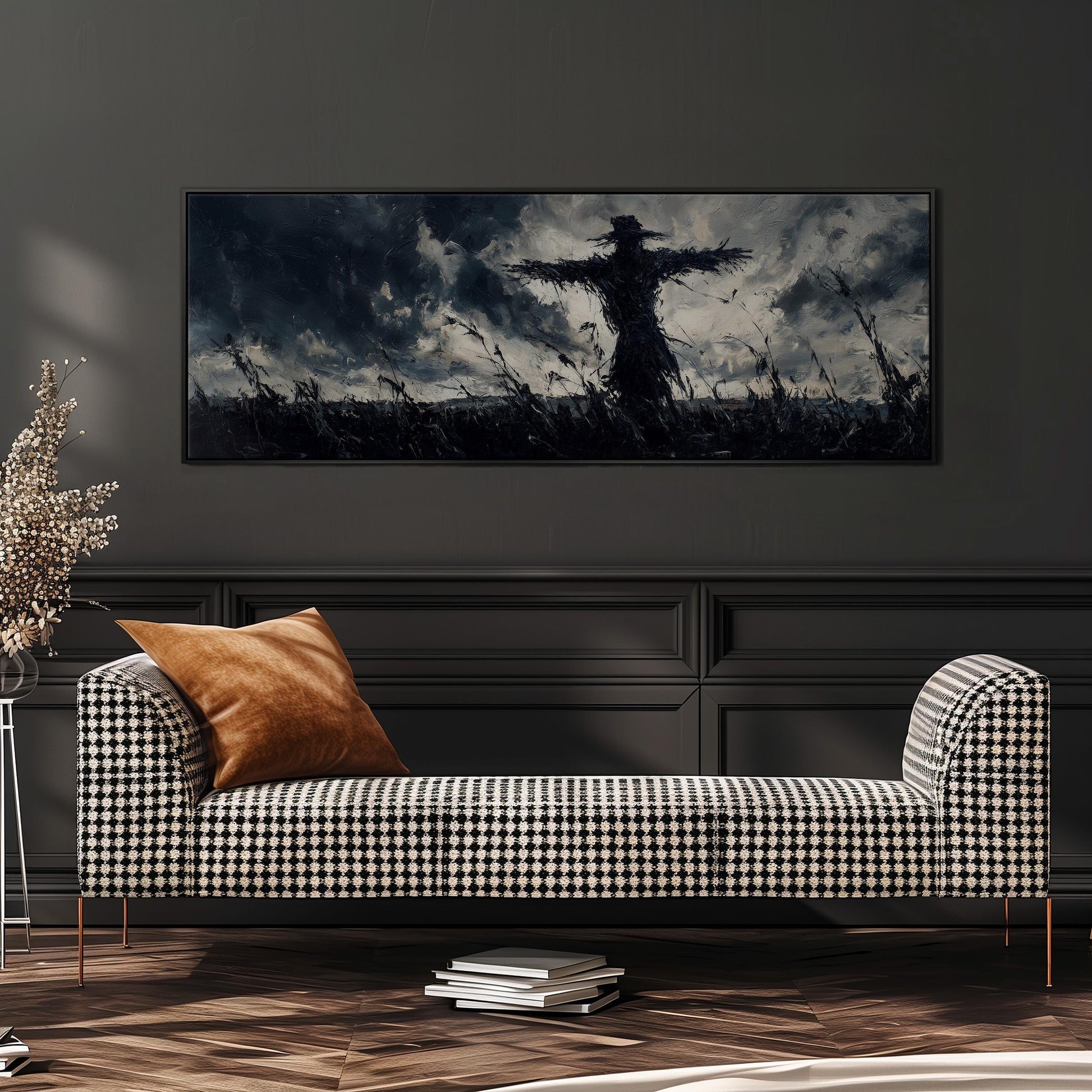 a large black and white photograph of a scarecrow in a field, hanging on a wall above a black and white checkered sofa.