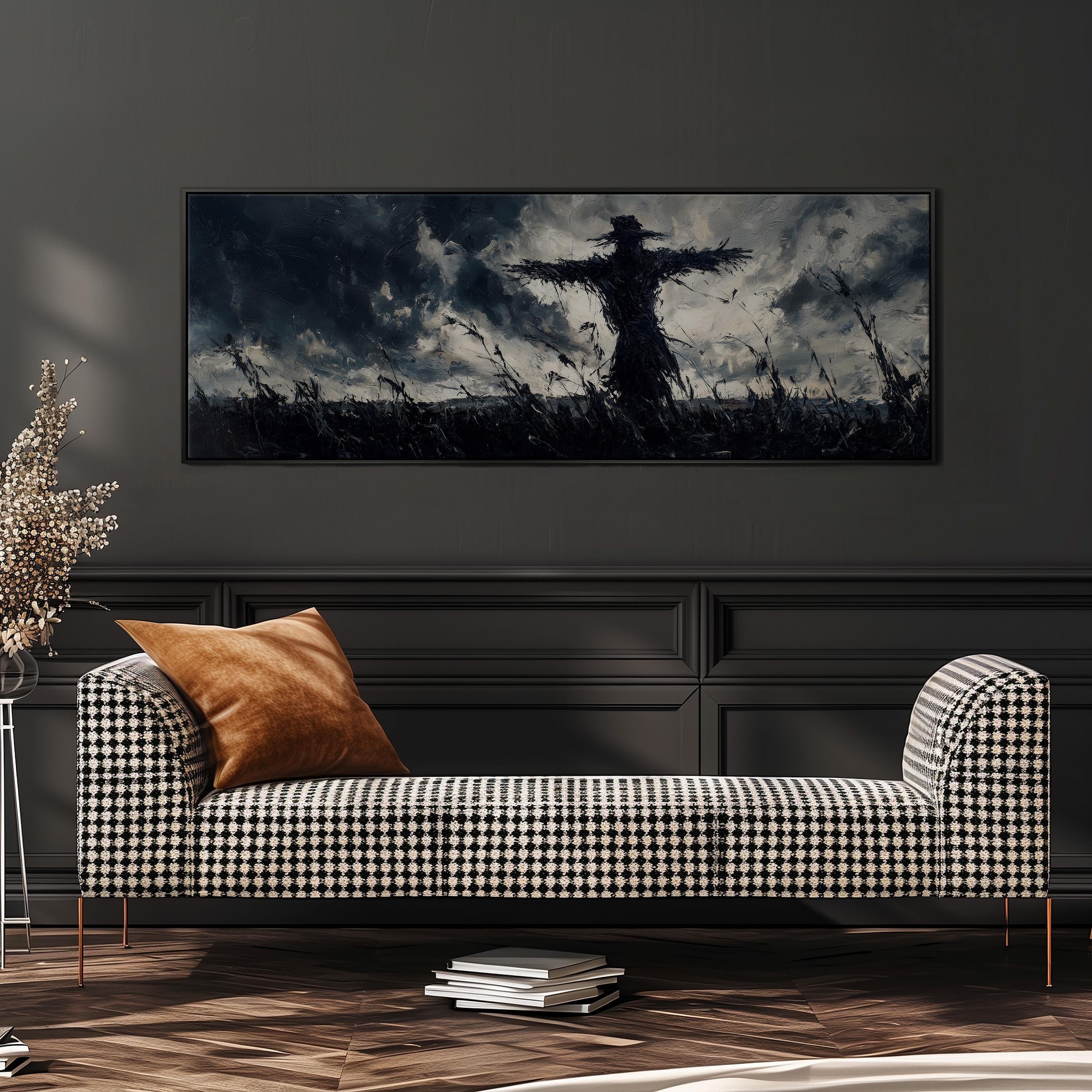 a large black and white photograph of a scarecrow in a field, hanging on a wall above a black and white checkered sofa.