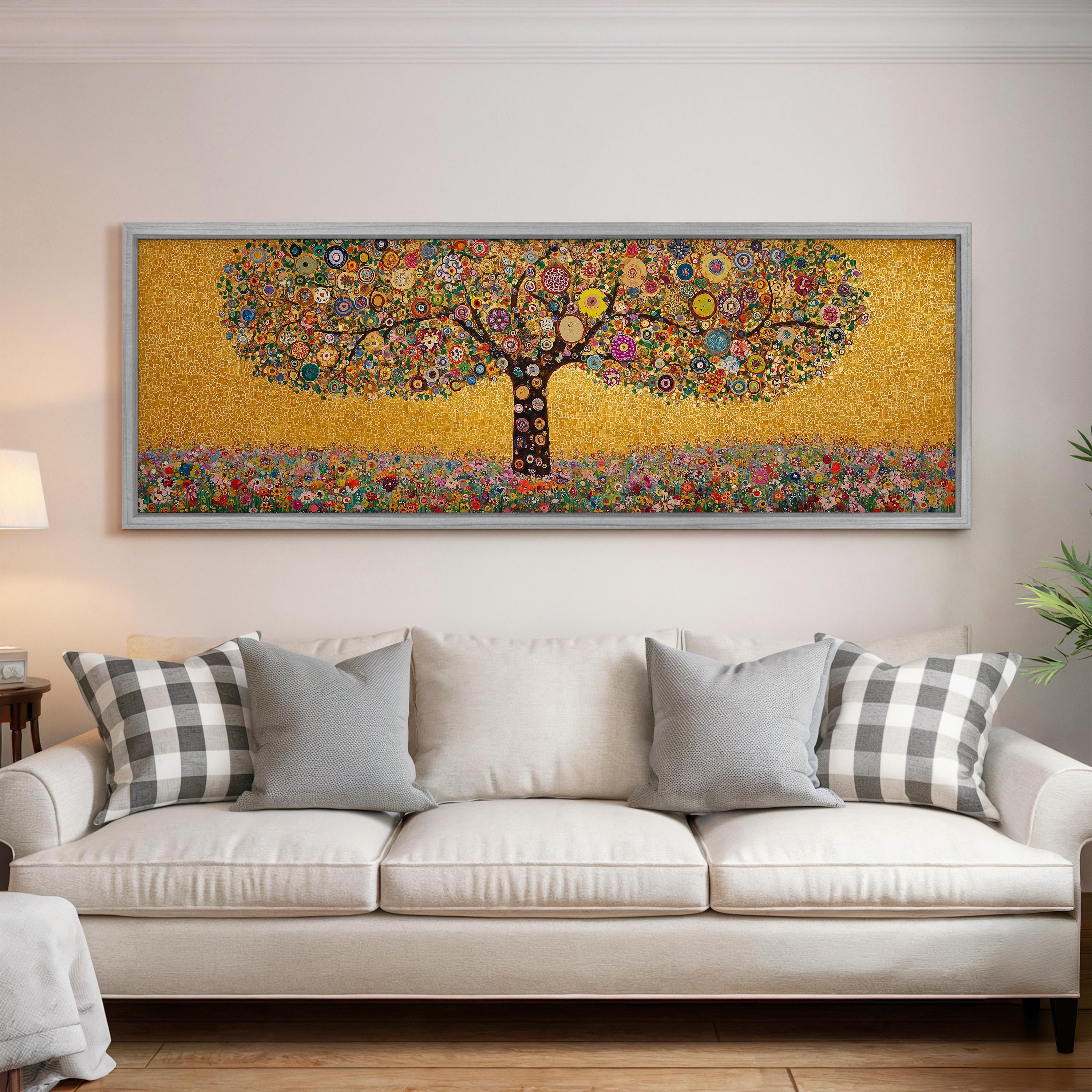 a large, colorful painting of a tree hanging on a wall above a white couch with gray and white pillows.