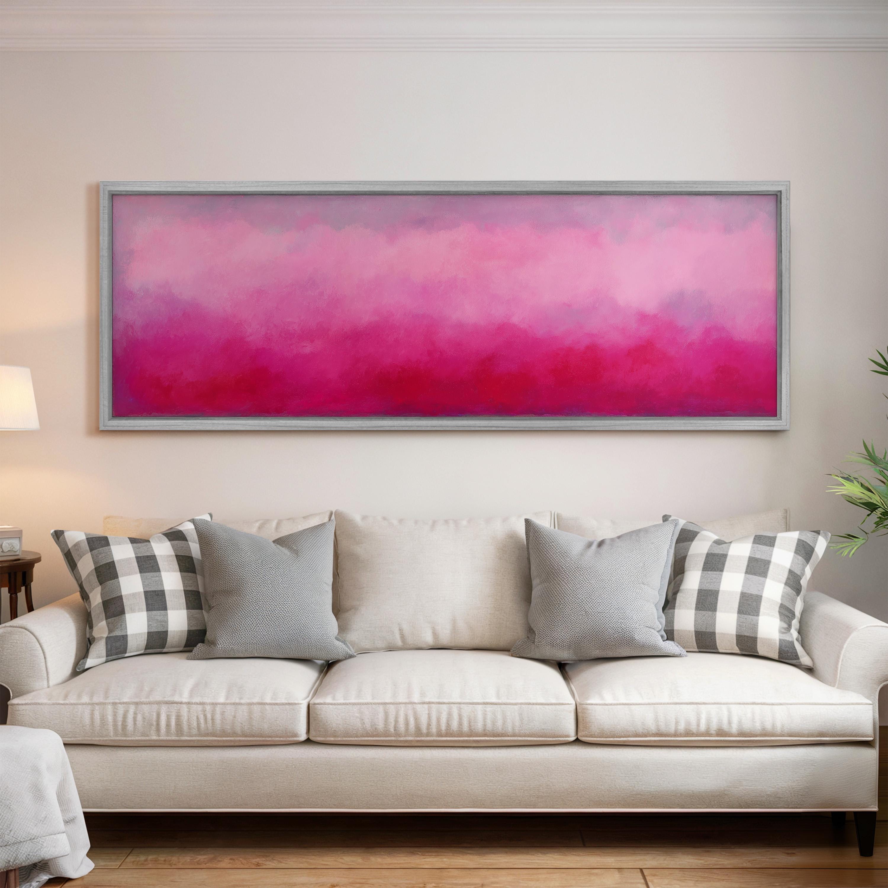 a large, rectangular painting hanging on a white wall above a white couch with gray and black plaid throw pillows.