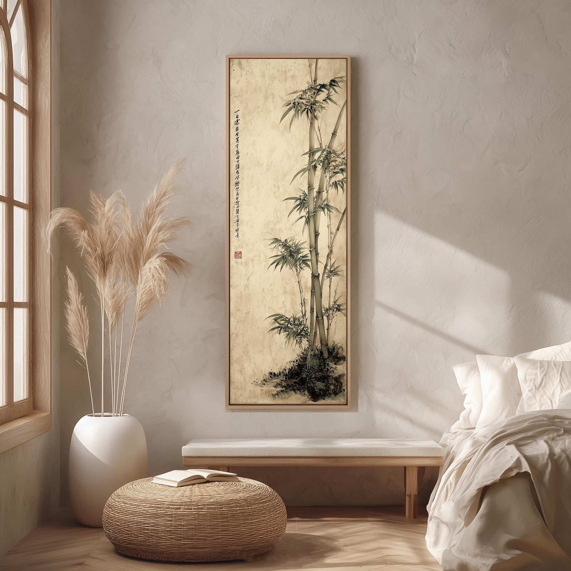 a serene and minimalist bedroom with a large bamboo painting hanging on the wall, a white bed with a white pillow, a white vase with tall potted plants, and a woven ottoman.