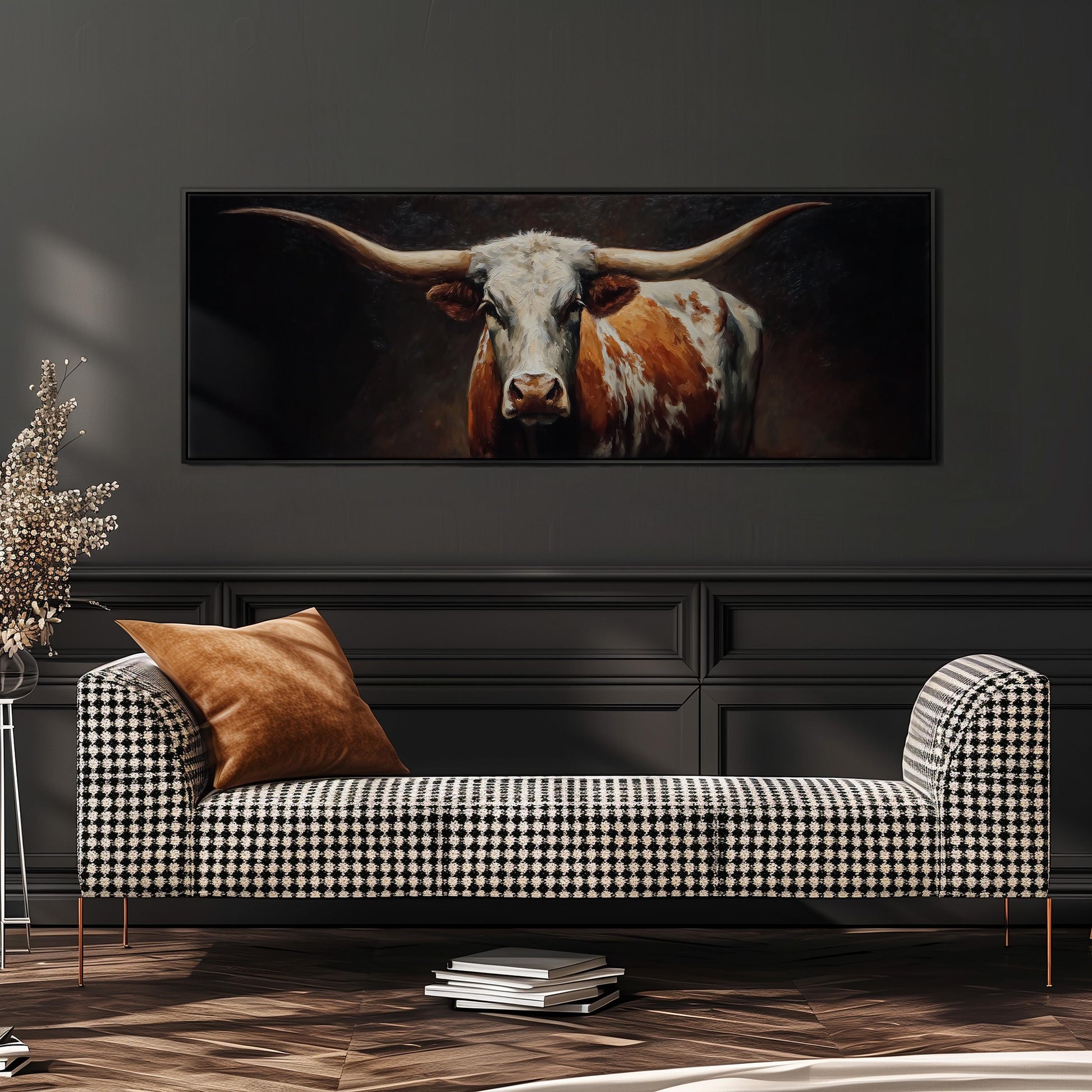 a large framed painting of a bull with long horns, hanging on a wall above a black and white checkered sofa in a living room setting.