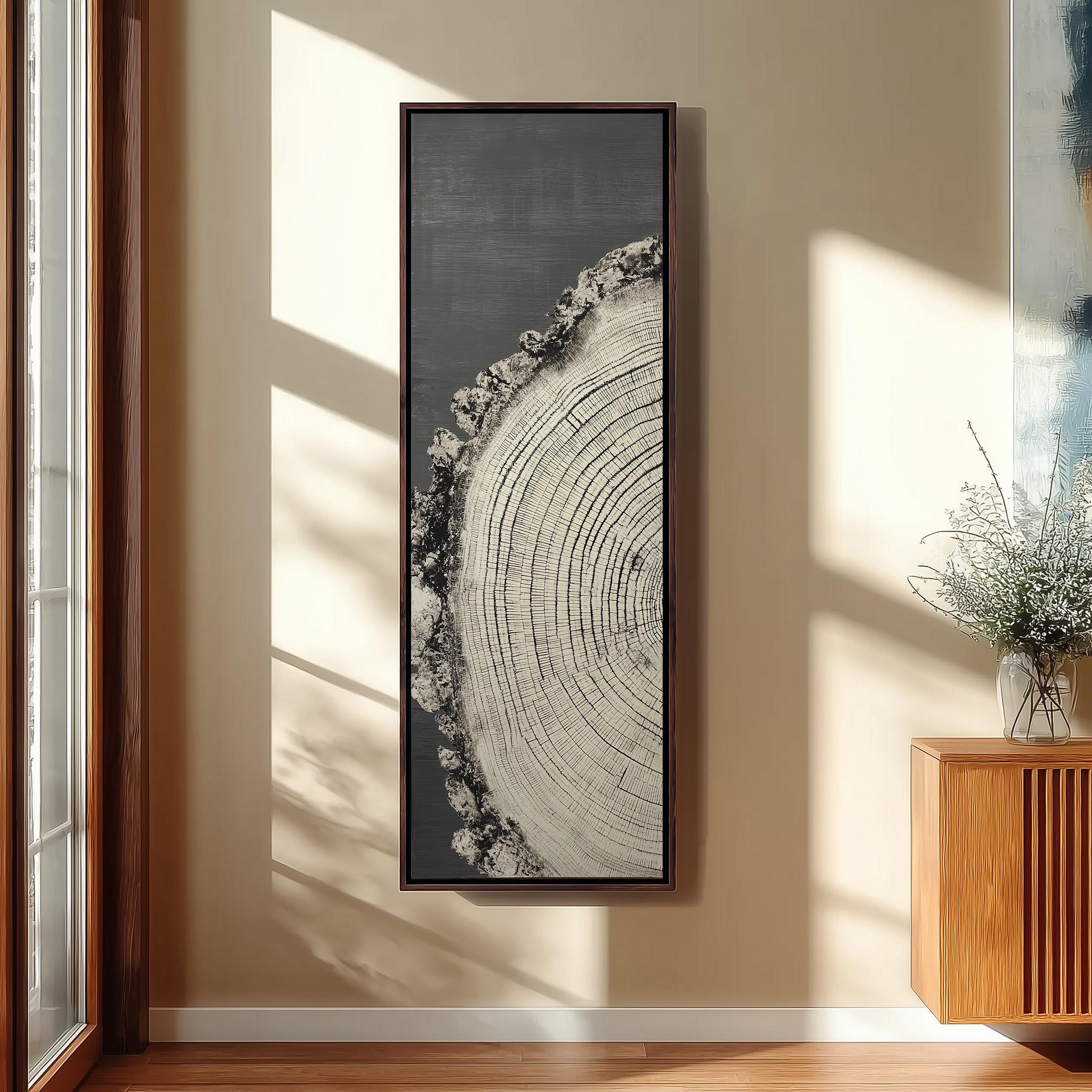 a large, framed artwork depicting a tree stump with concentric rings, hanging on a wall in a room with a wooden cabinet and a vase of flowers.
