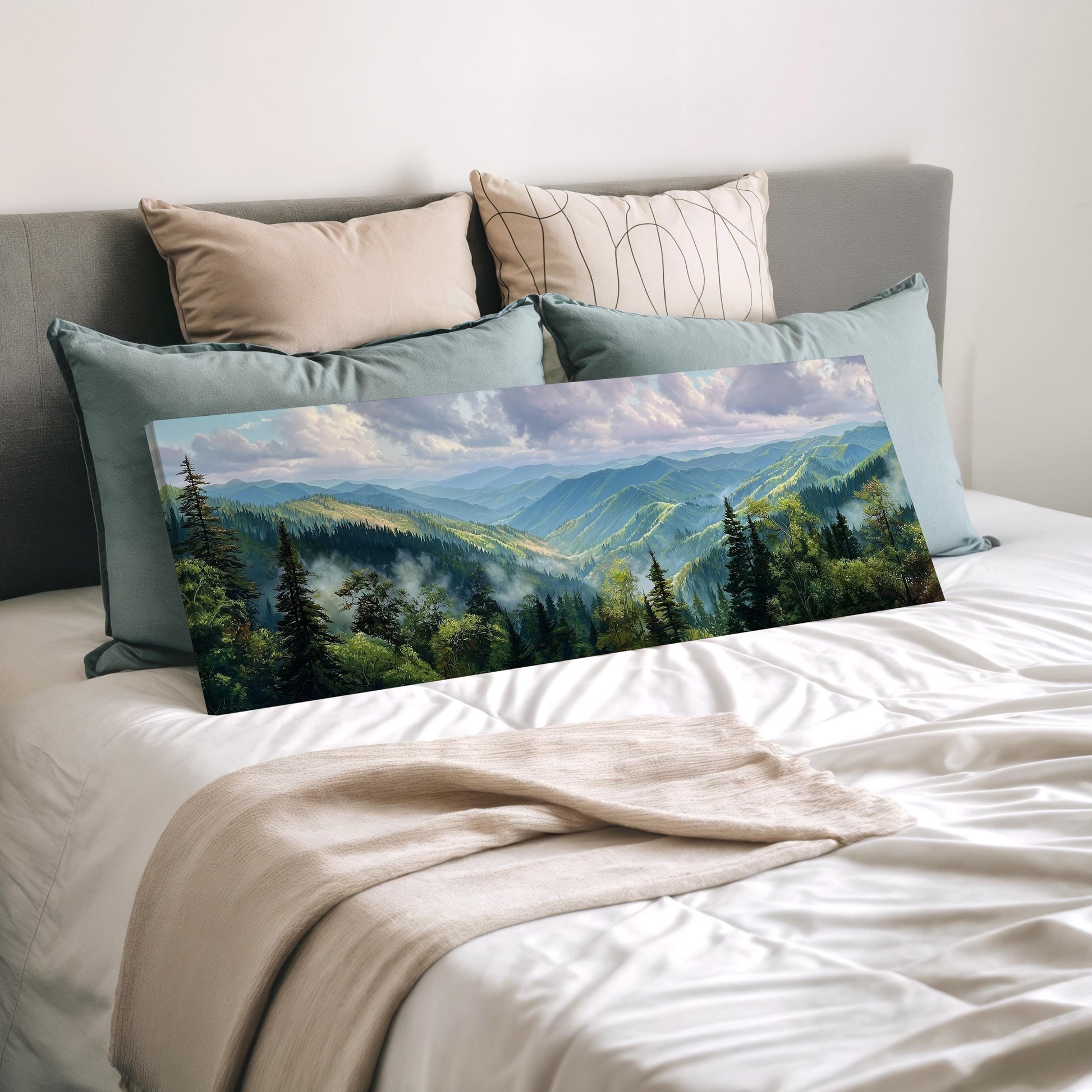 a large landscape painting of a mountainous forest scene, displayed on a bed with a white comforter and pillows.