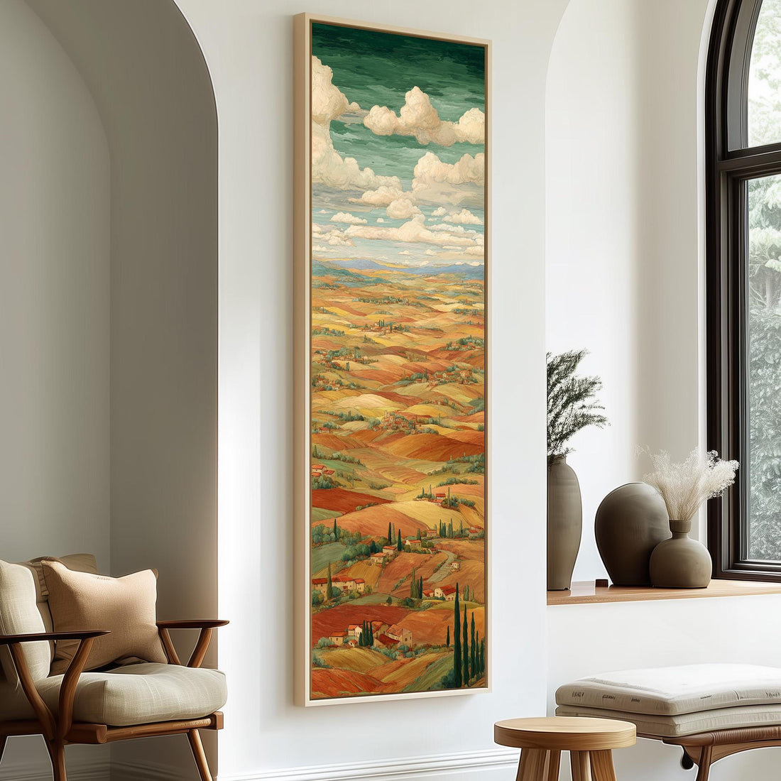 a large painting of a countryside landscape hanging on a wall, with a cozy seating area and decorative elements in the foreground.