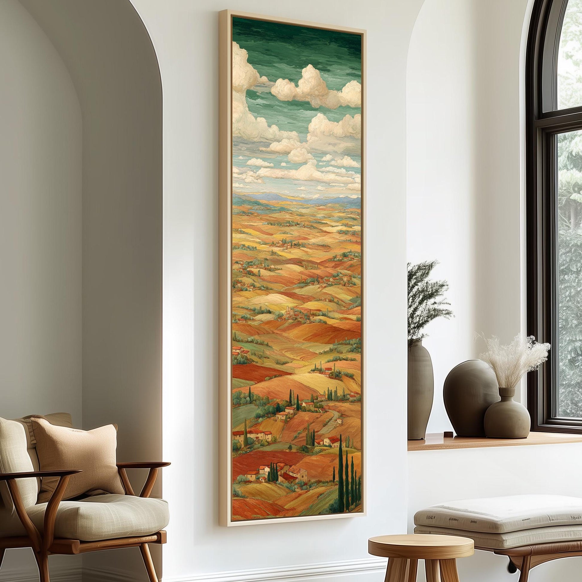 a large painting of a countryside landscape hanging on a wall, with a cozy seating area and decorative elements in the foreground.