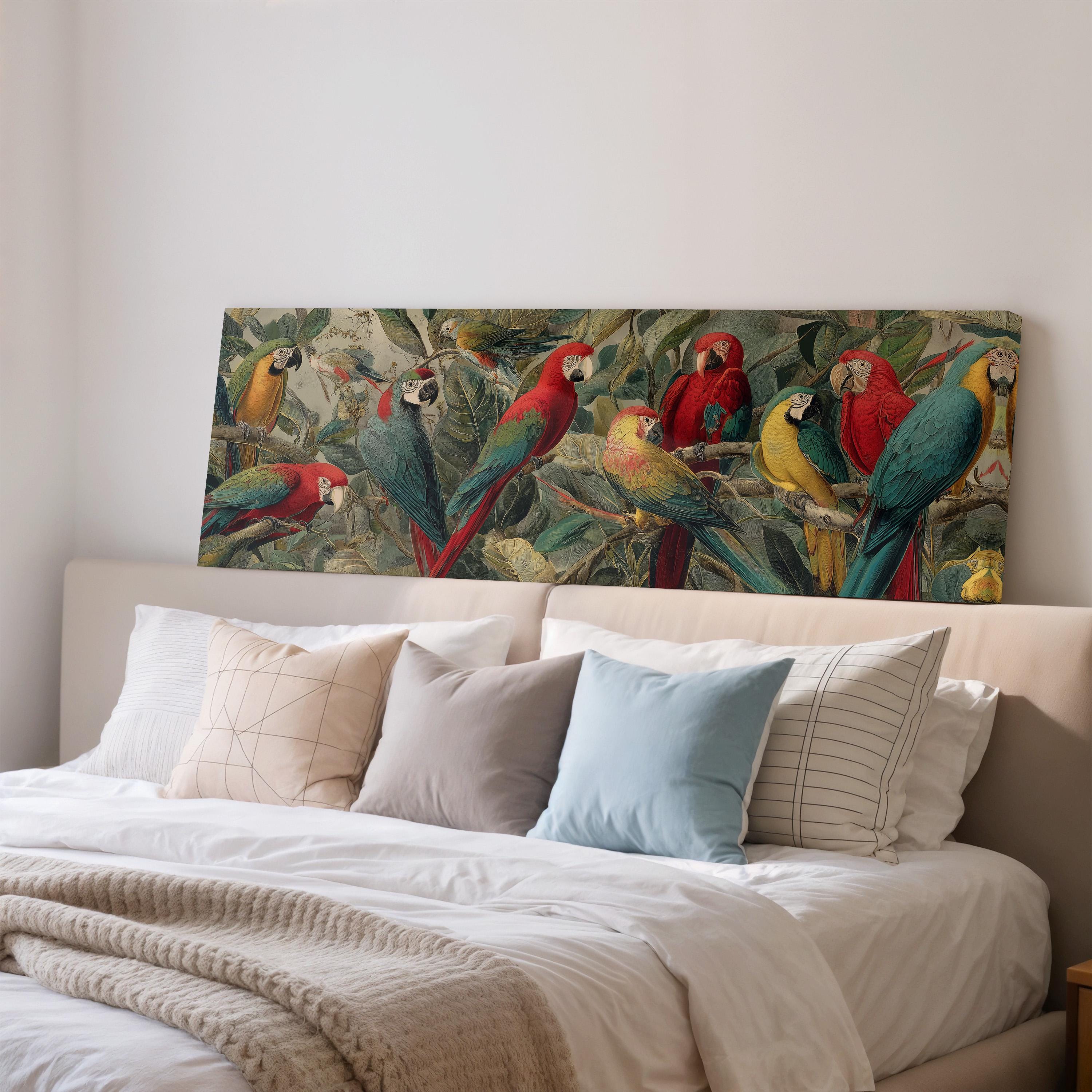 a large painting of colorful parrots on a wall above a bed with white pillows and a gray blanket.