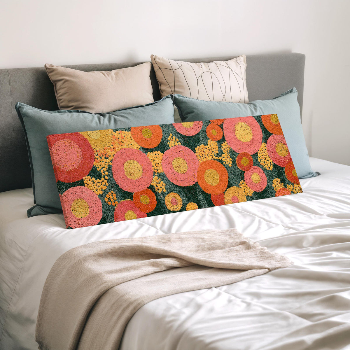 Pink circle blooms wide panoramic canvas print laid on a bed to show its size