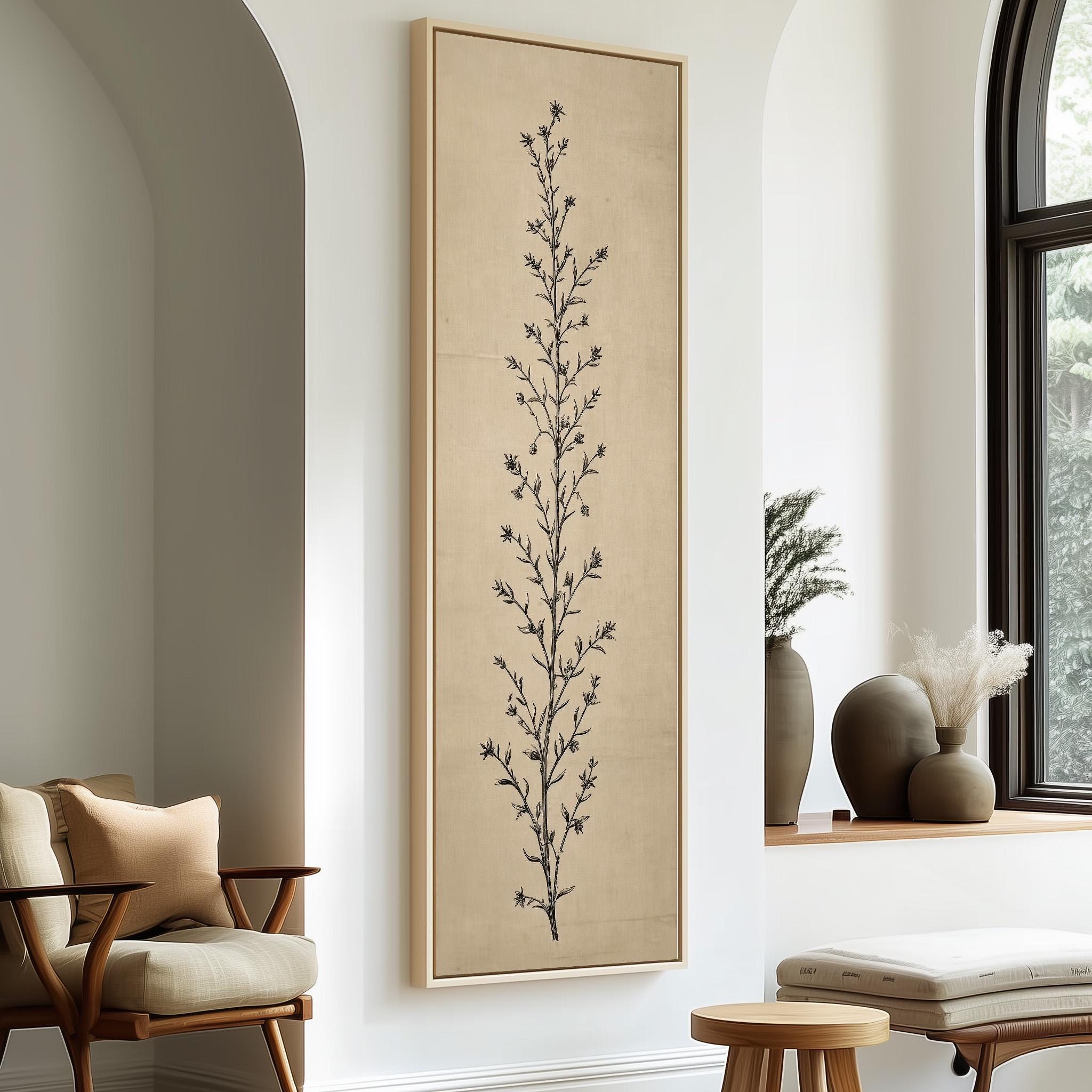 a minimalist living room with a large framed artwork of a tree on the wall, a wooden chair, a small table, and a window with a plant on the sill.