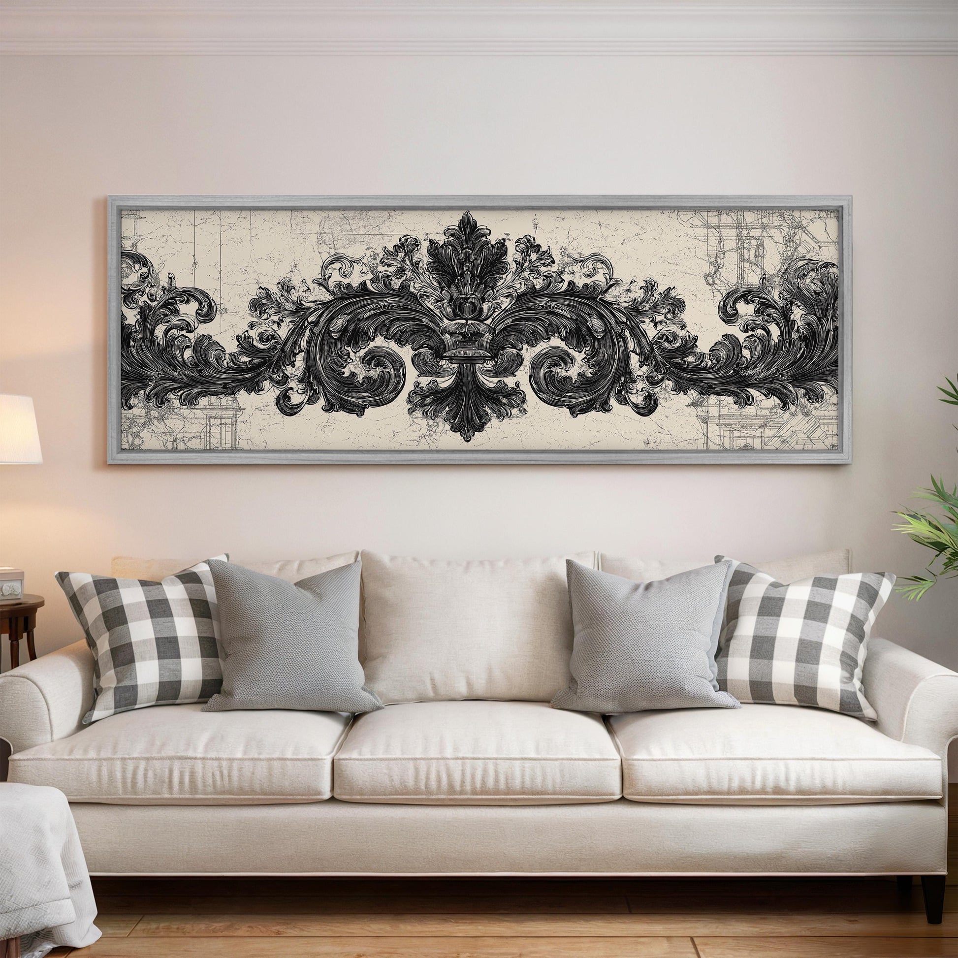 a large, ornate black and white artwork hanging on a wall above a white couch with gray and white patterned pillows.