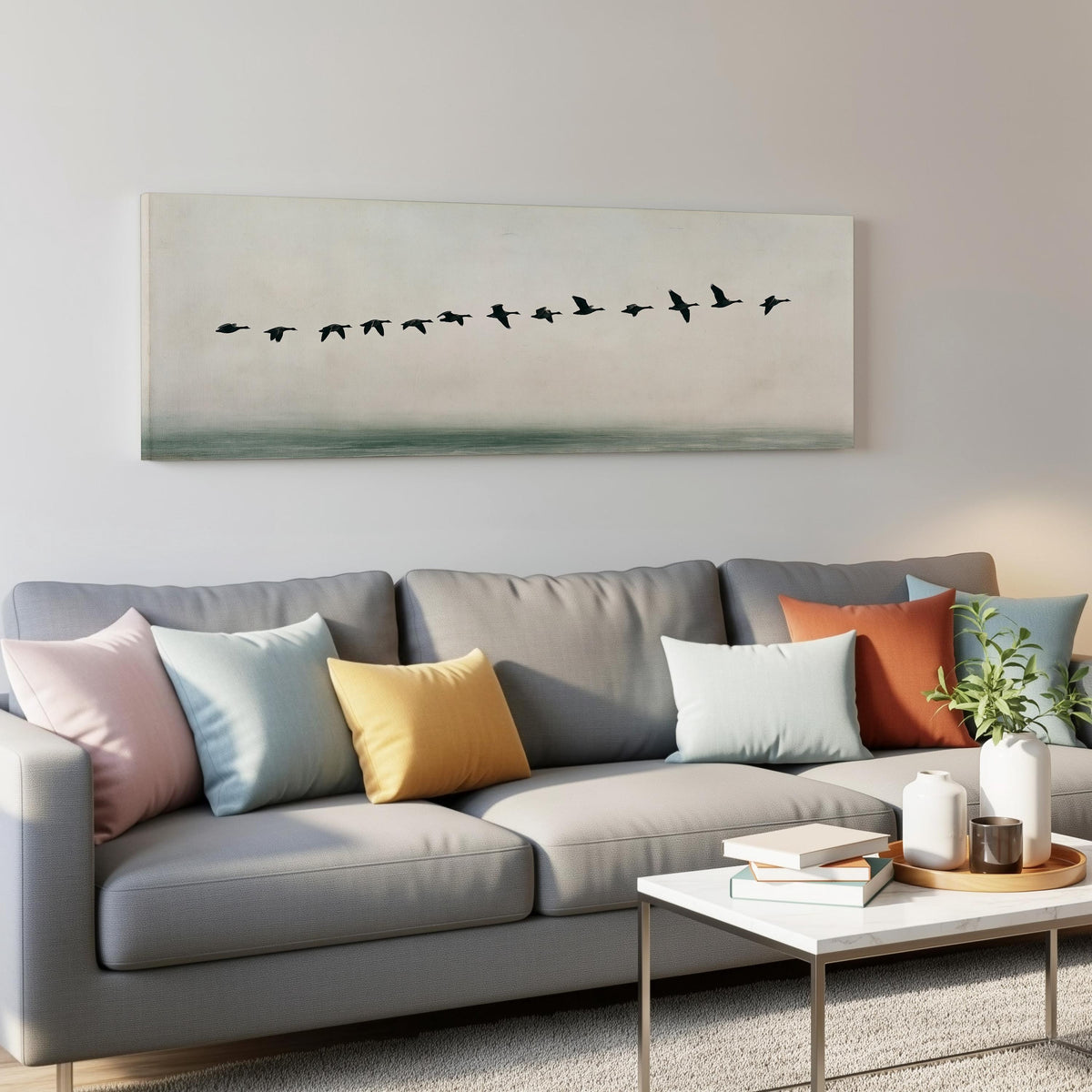 Geese flying over still water panoramic canvas print above a grey sofa in a living room