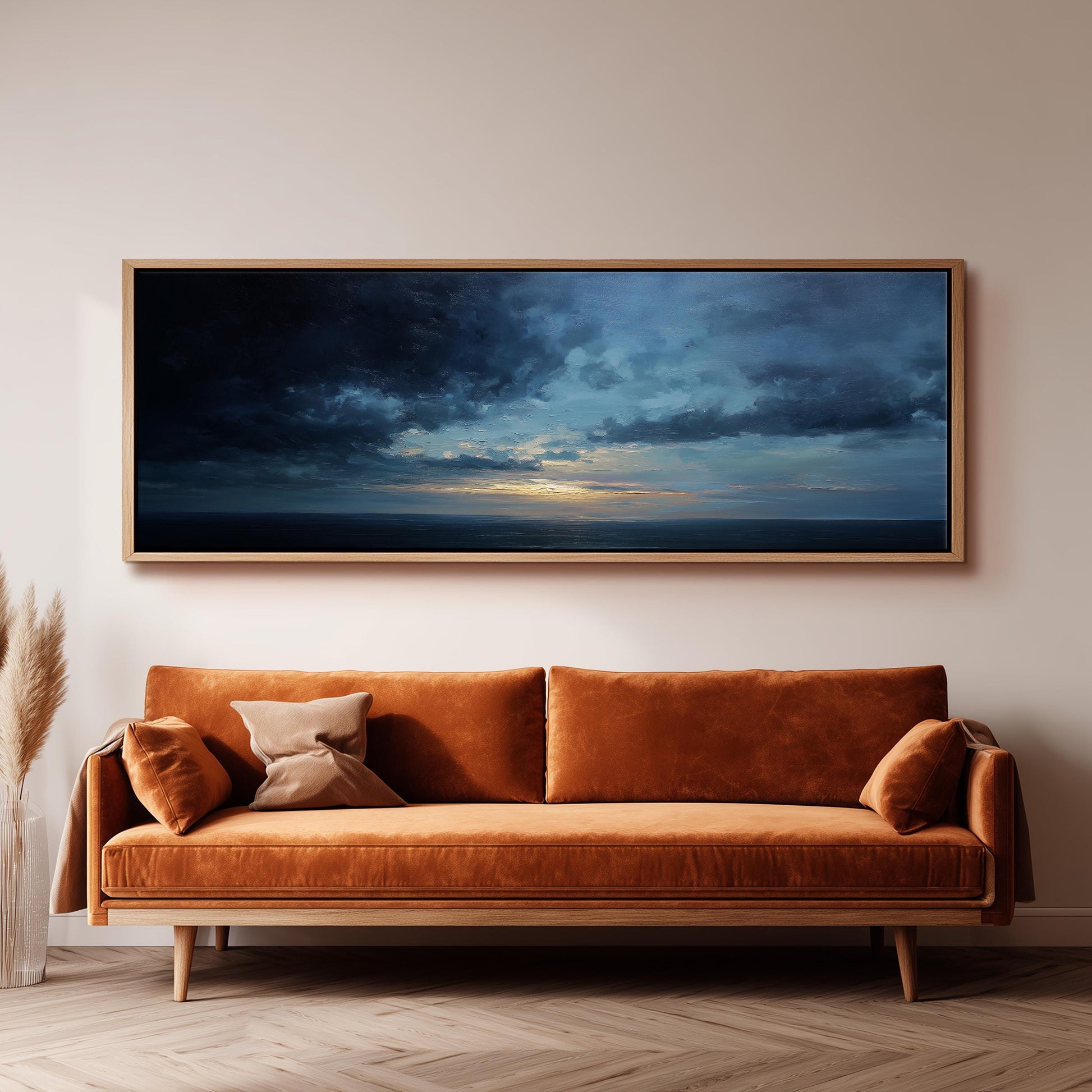 a large, framed painting of a stormy sky hanging above a brown sofa with two pillows.