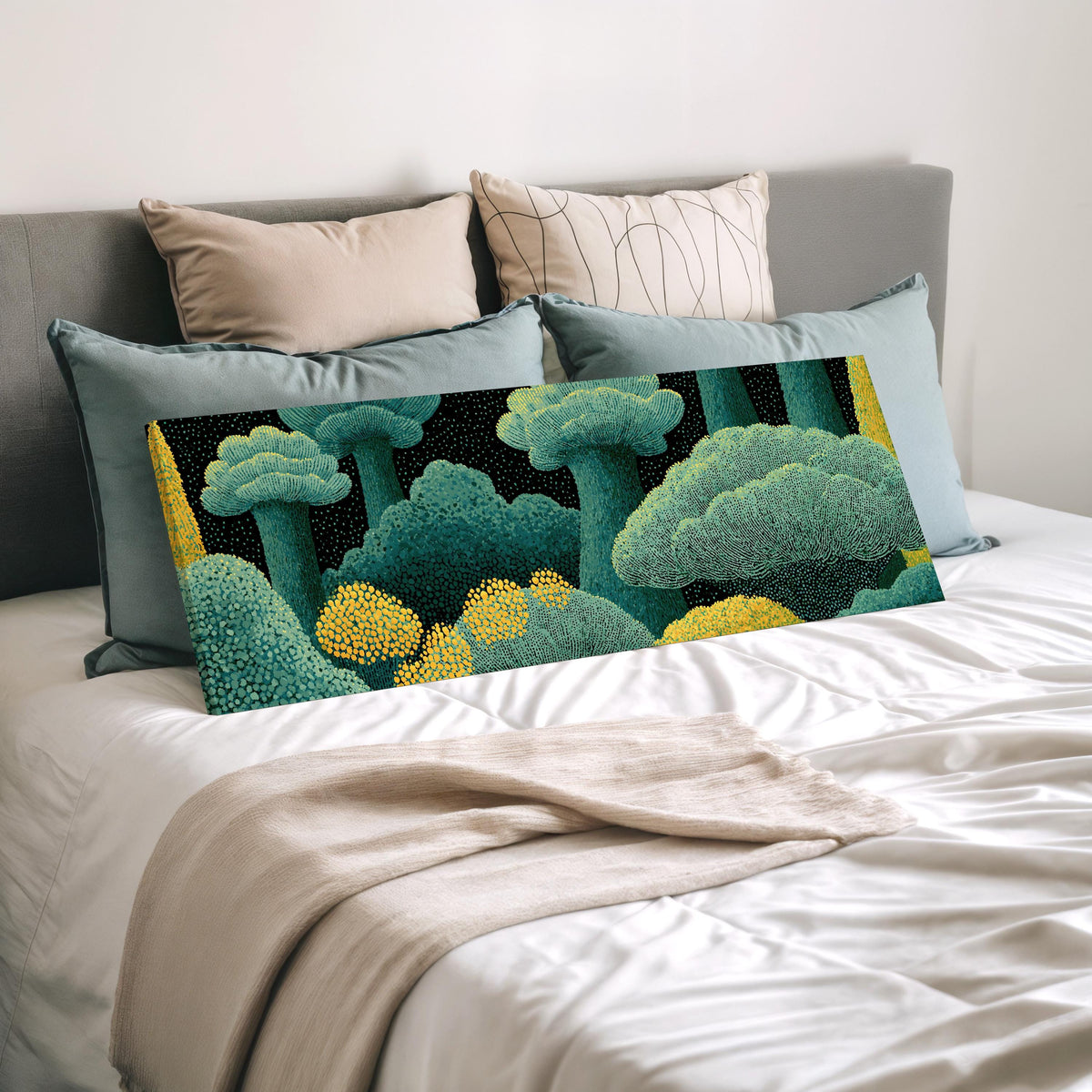Teal dotted treetops wide panoramic canvas print laid on a bed to show its size