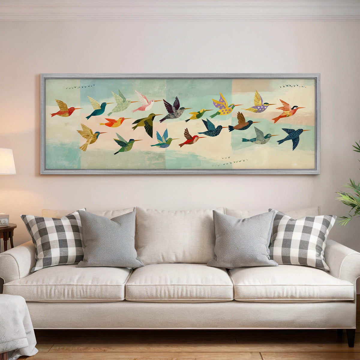 Flock of colorful hummingbirds panoramic canvas print above a white sofa in a bright living room