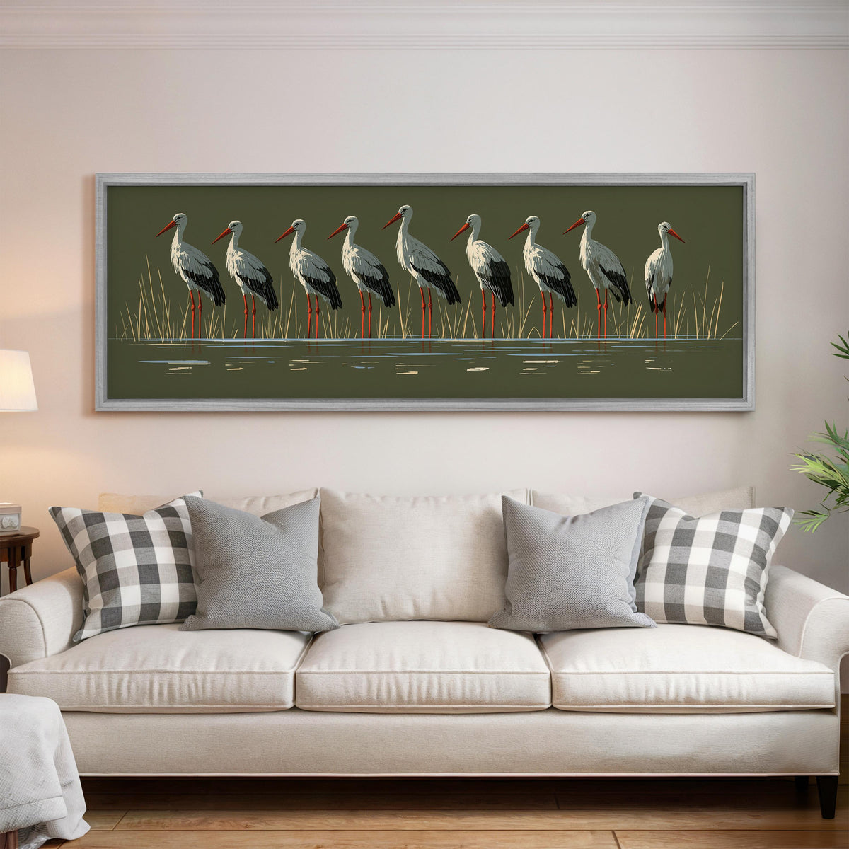 Flock of storks on olive green panoramic canvas print above a white sofa in a bright living room
