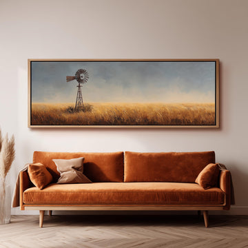 a large painting of a windmill in a field, hanging on a wall above a brown sofa.