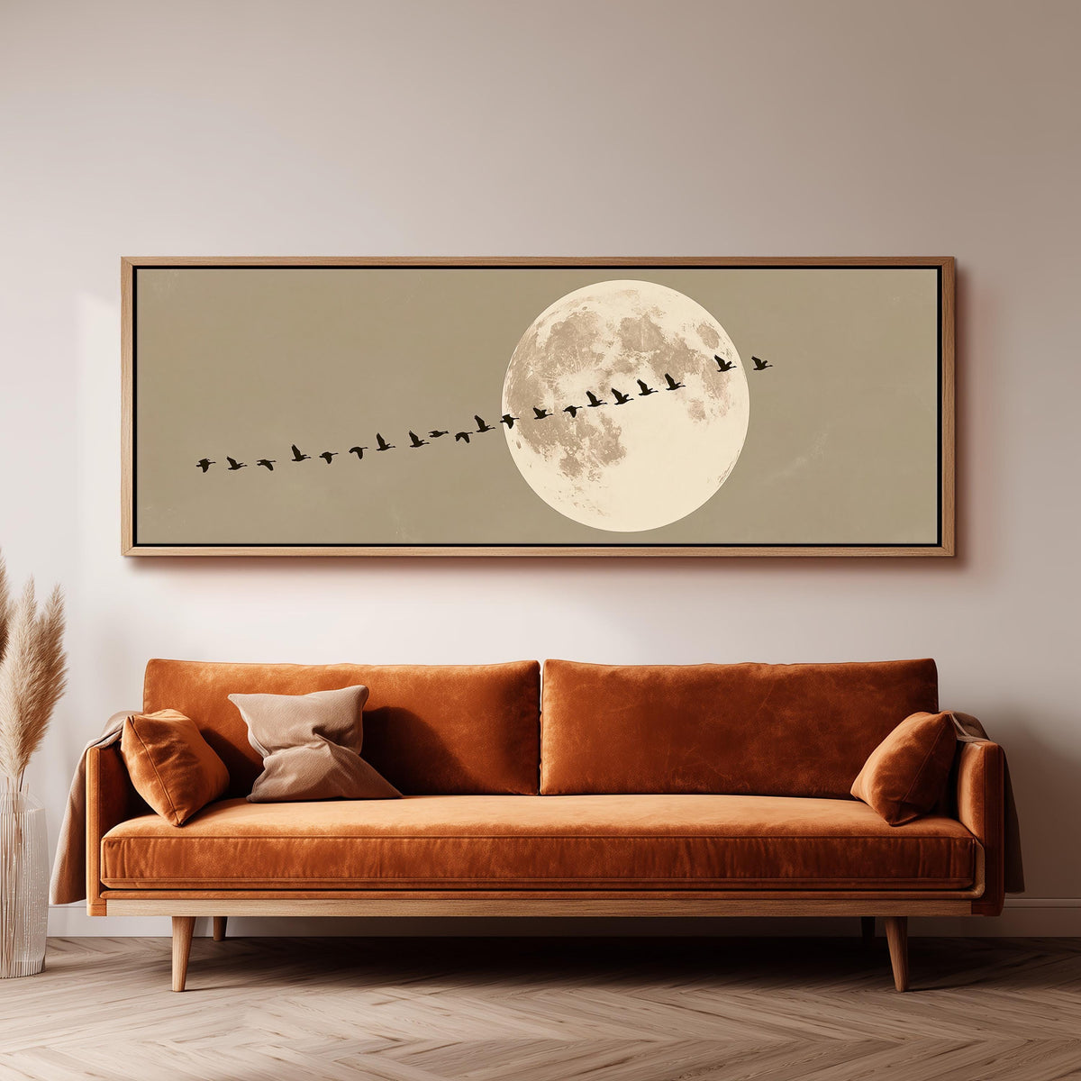 Geese flying past a full moon panoramic canvas print above a sofa in a living room