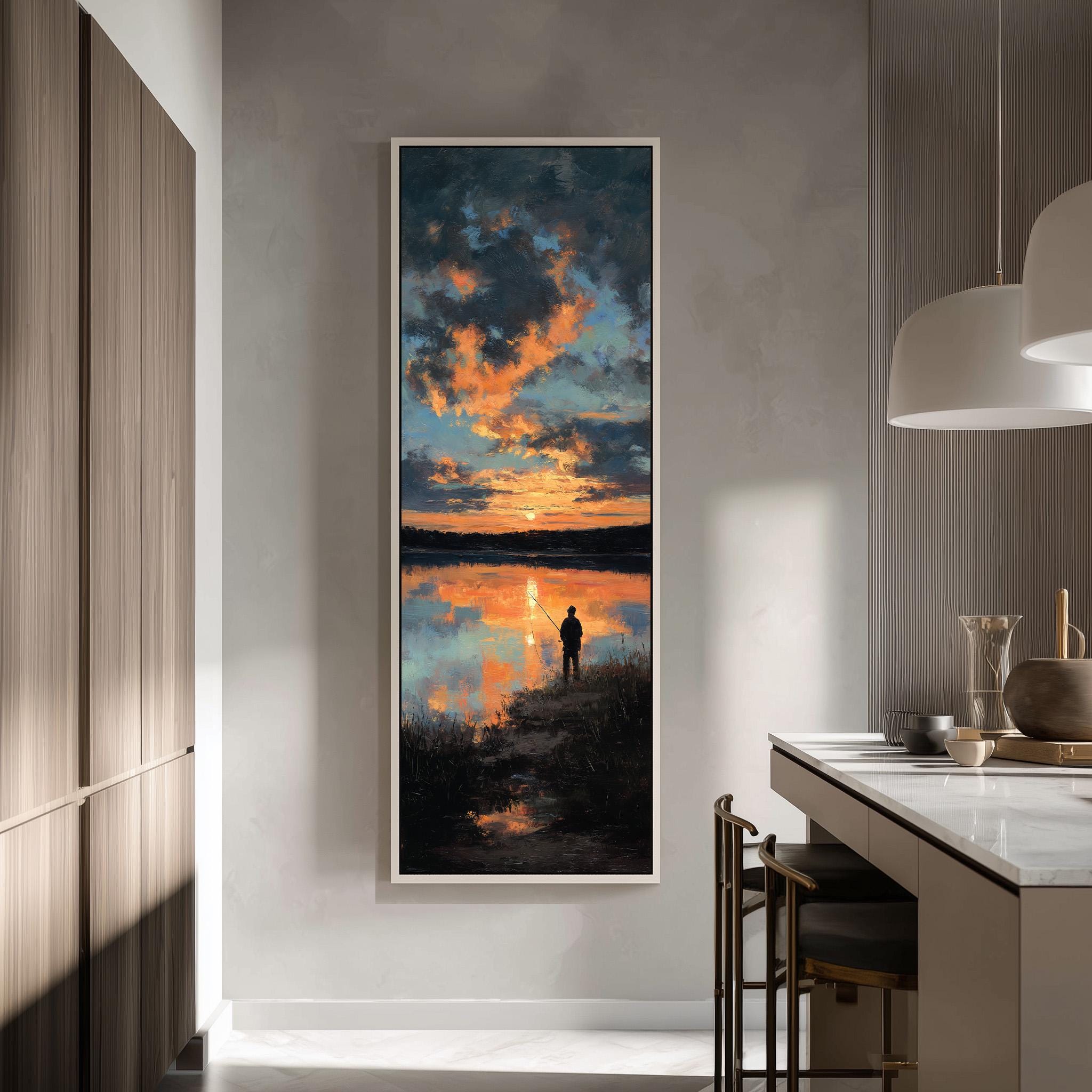 a large framed painting of a serene landscape depicting a person fishing at sunset.
