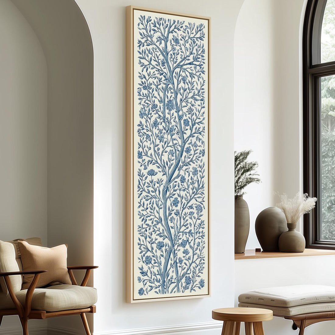 a living room with a large blue and white floral print hanging on the wall, a wooden chair, a small table, and a window with a plant on the sill.