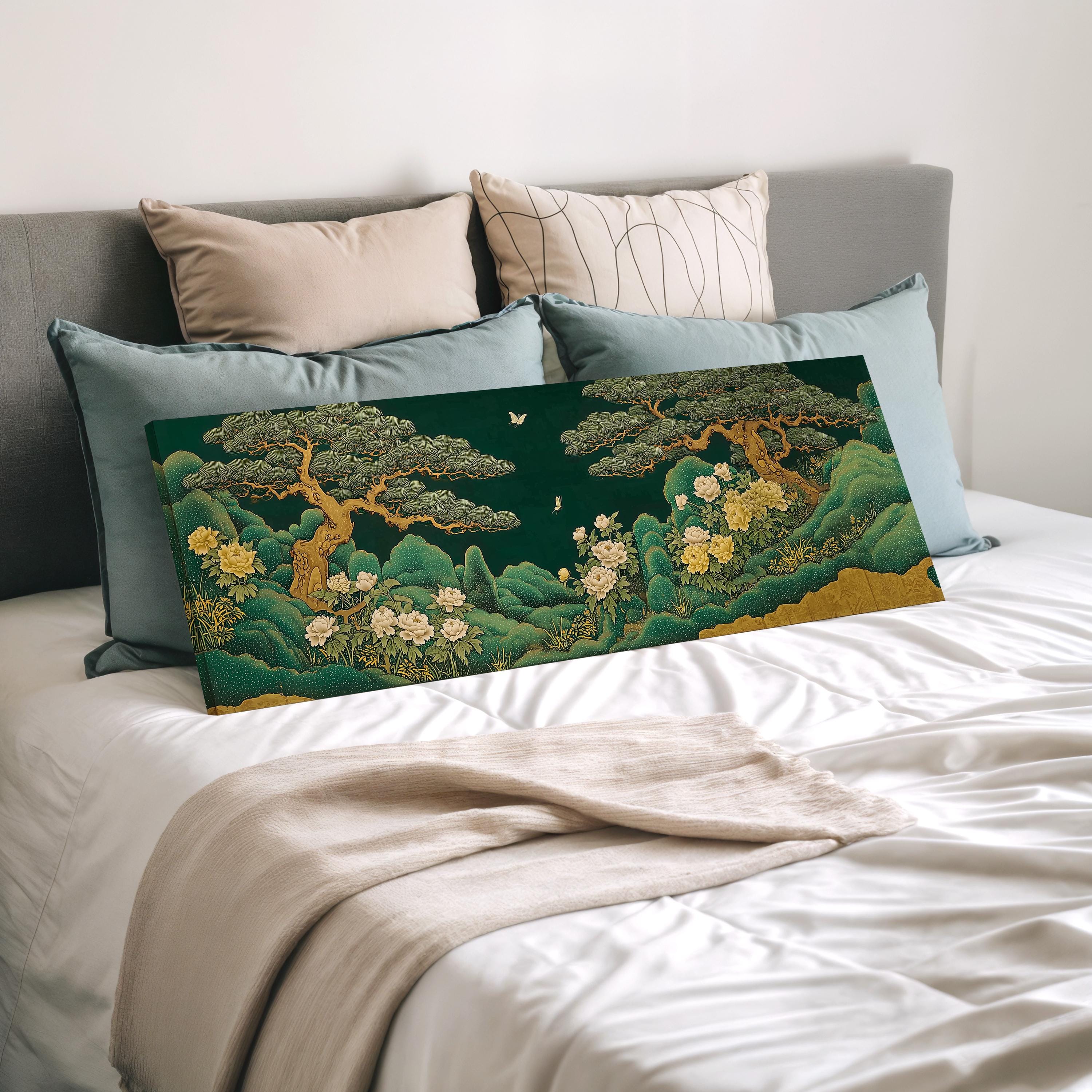 a large, colorful painting of a landscape with trees and flowers displayed on a bed, surrounded by pillows.