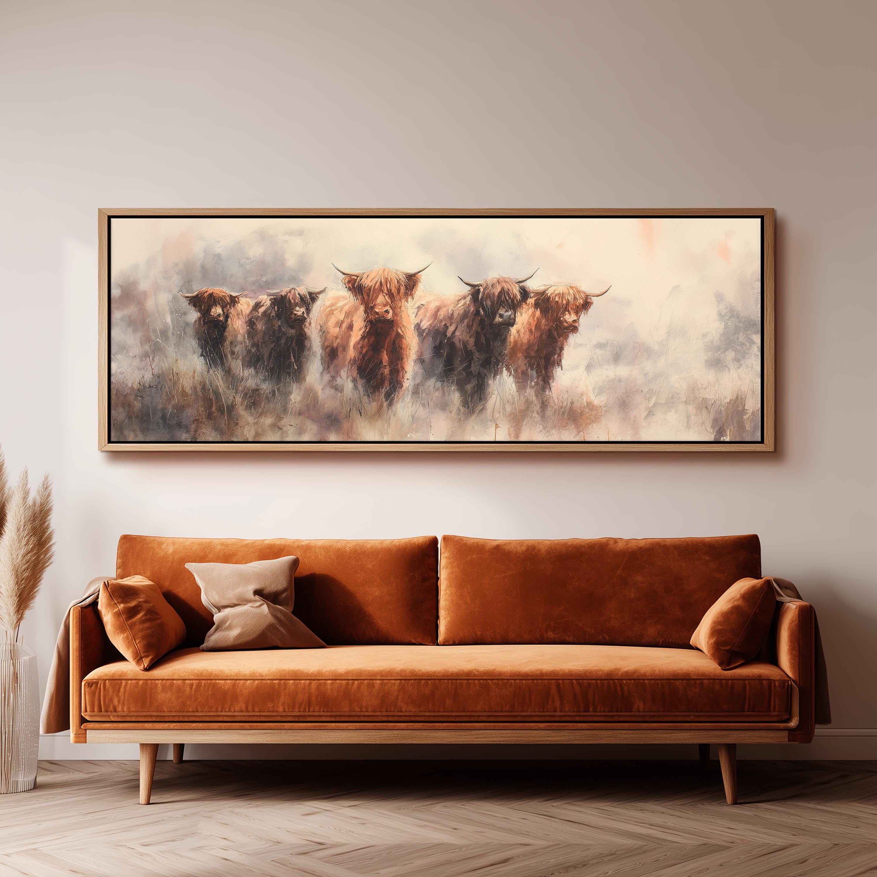a large painting of a group of brown cows on a white background, hanging on a wall above a brown sofa.