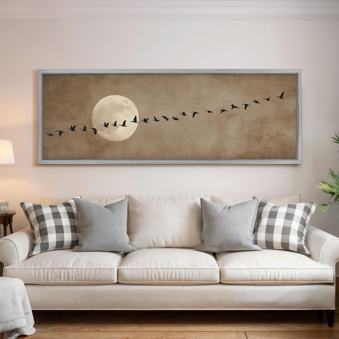 a large framed artwork depicting a flock of birds flying in formation, with a full moon in the background.