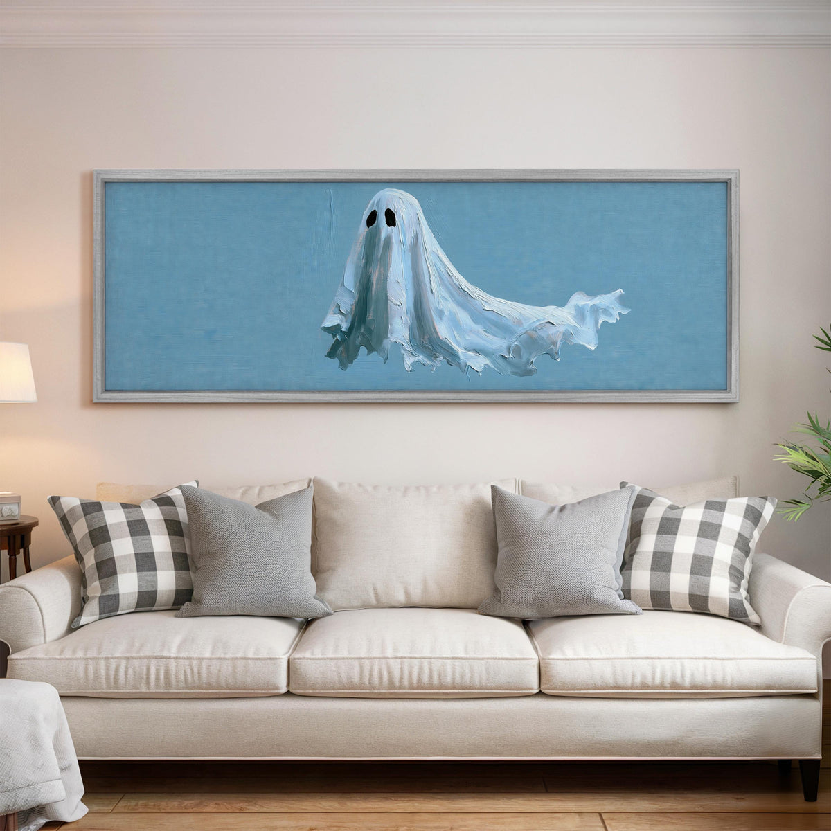 Floating ghost on blue panoramic canvas print above a white sofa in a bright living room