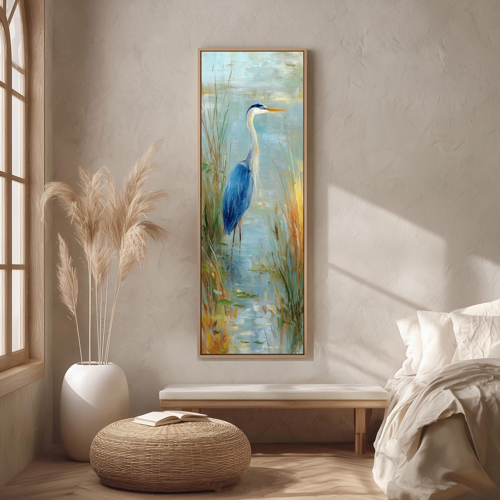 a large painting of a blue heron standing in a pond, hanging on a wall in a room with a window, a white bench, and a woven ottoman.