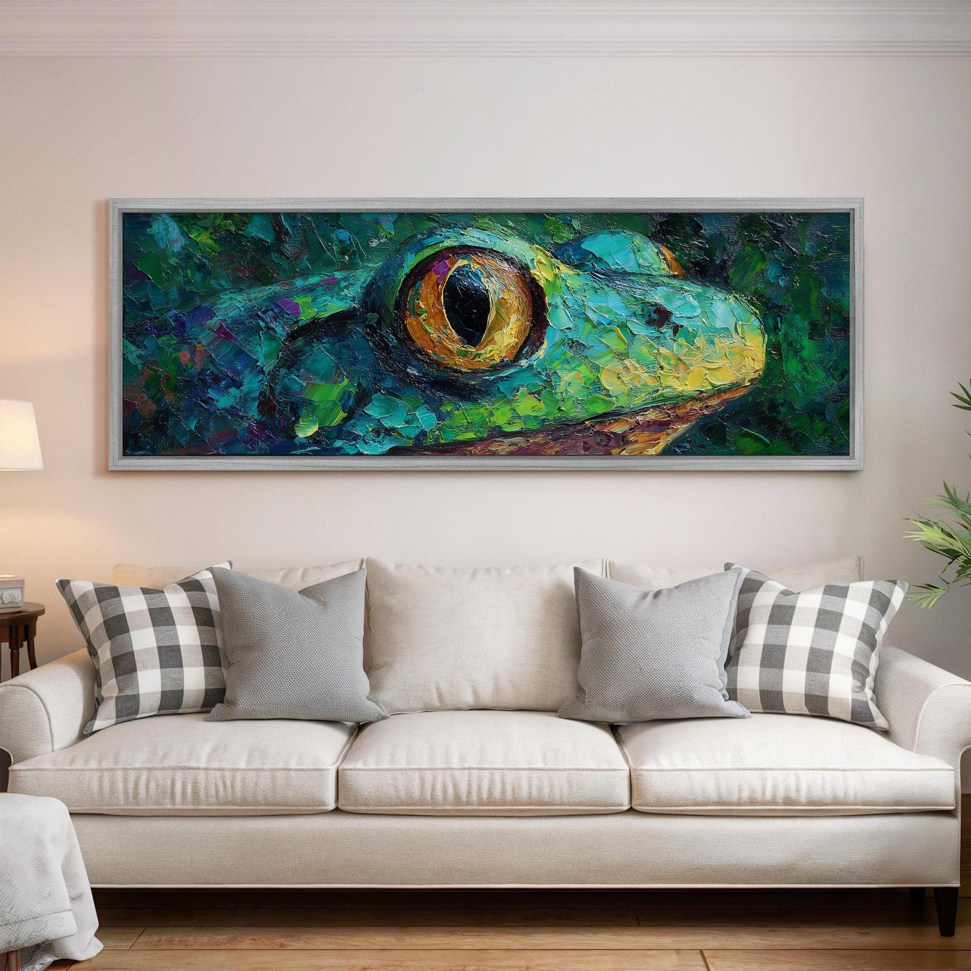 a large, colorful painting of a frog's face hanging on a wall above a white couch with gray and white plaid throw pillows.