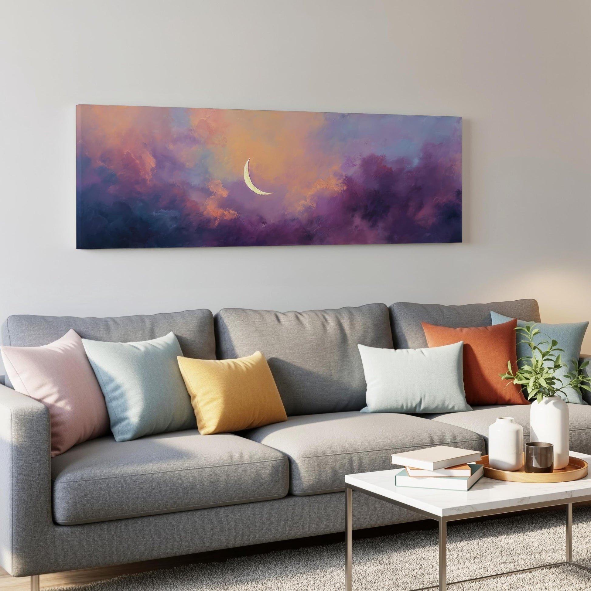 a gray couch with colorful throw pillows, a coffee table, and a painting of a crescent moon on the wall above it.